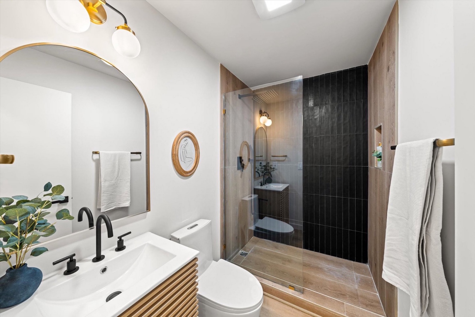 This full bathroom includes a stylish single vanity & glass walk-in shower