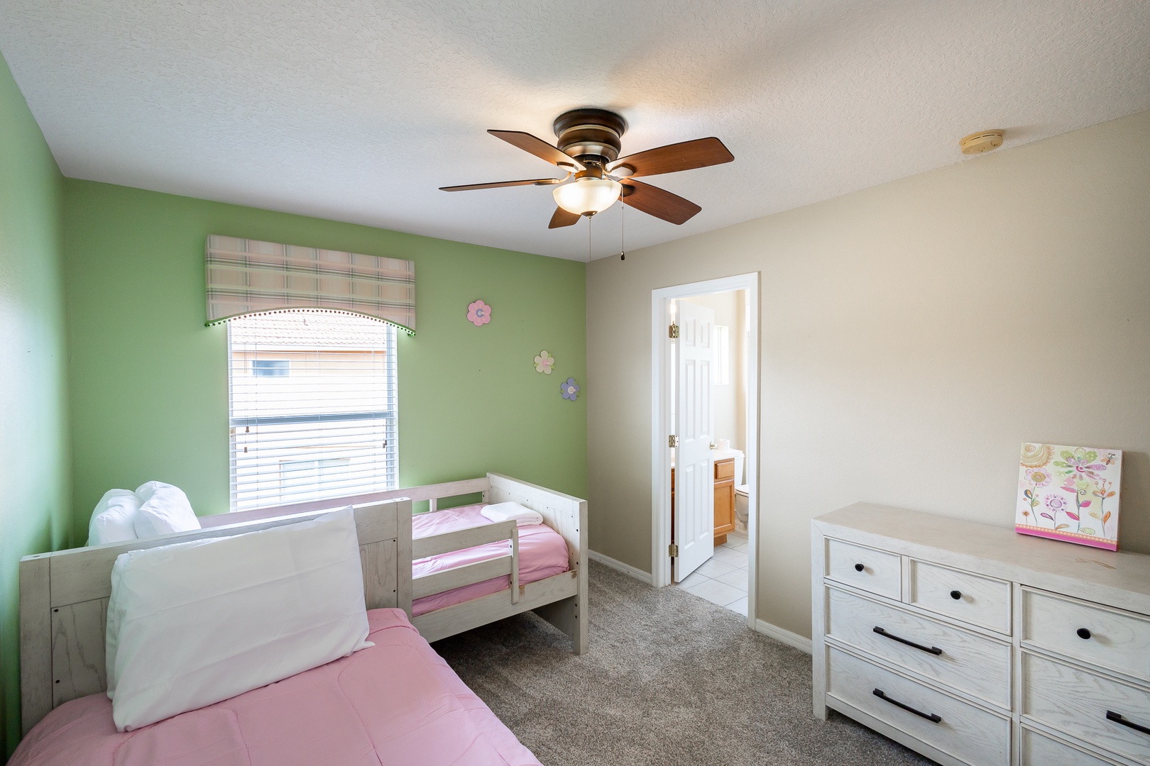 A 2nd twin bedroom offers a pair of twin beds, ceiling fan, & TV