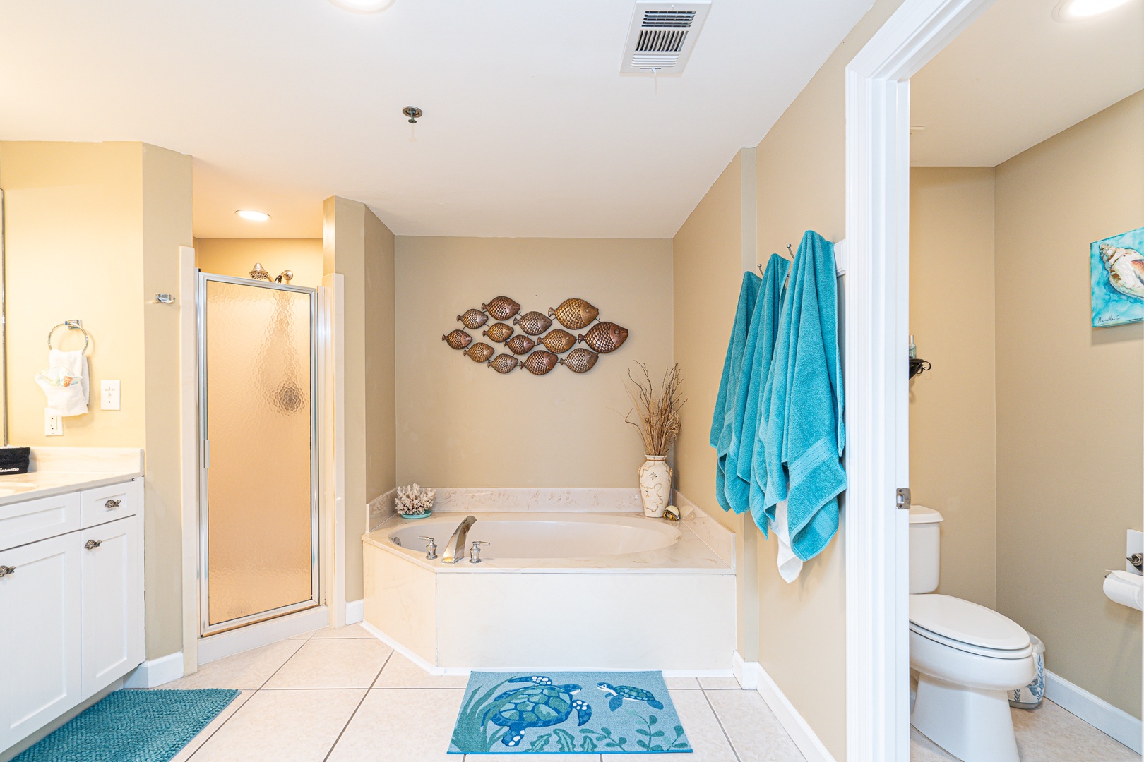 The master ensuite showcases a dual vanity, glass shower, & soaking tub