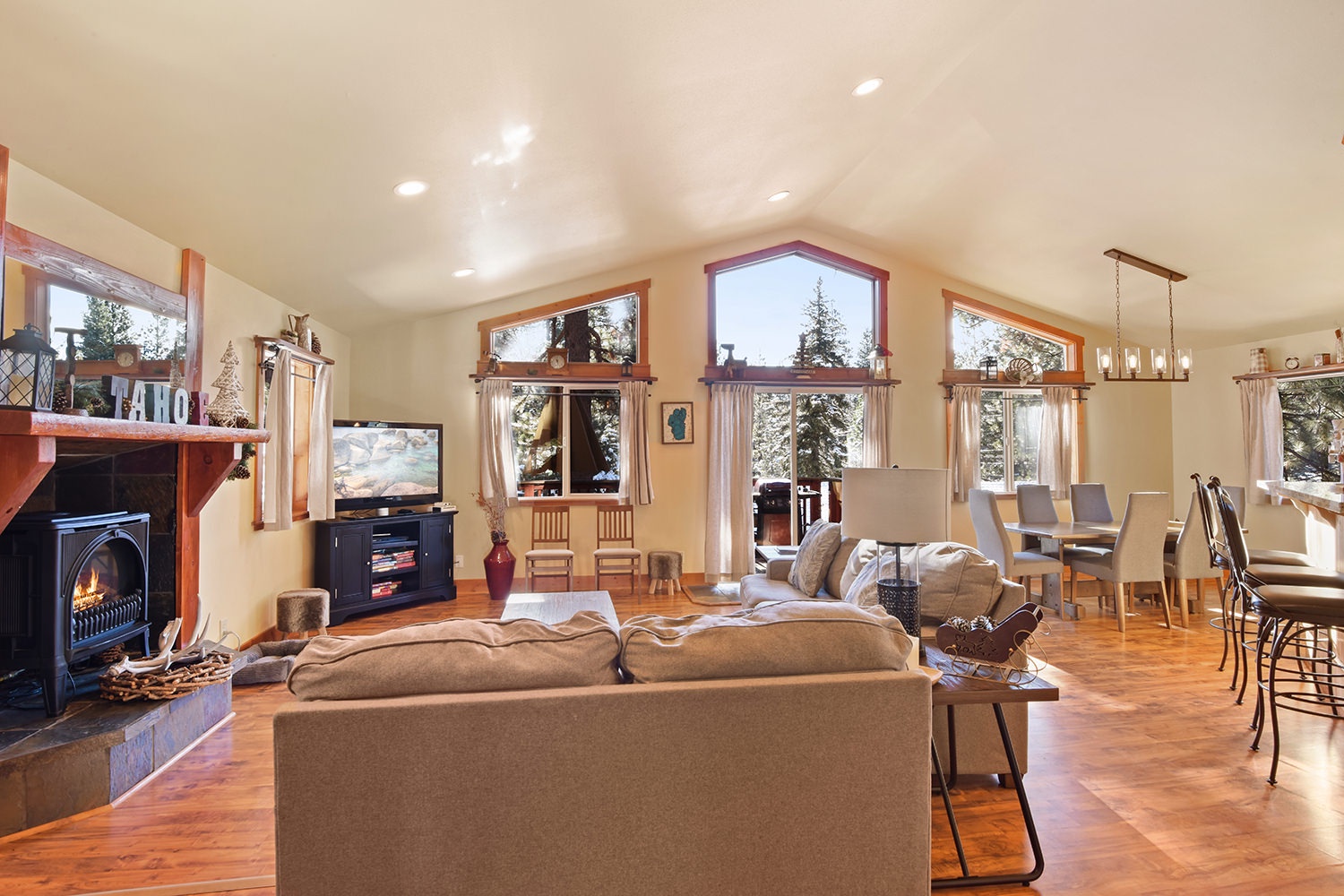 Open living space with gas fireplace, TV, and deck