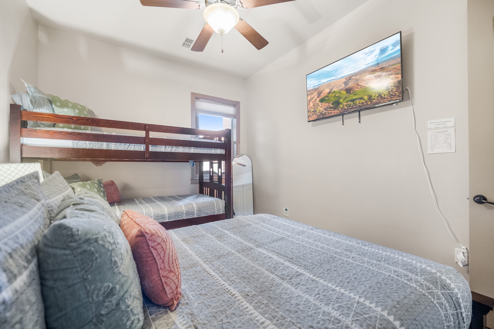 The serene second bedroom contains a queen & twin bunk bed & Smart TV