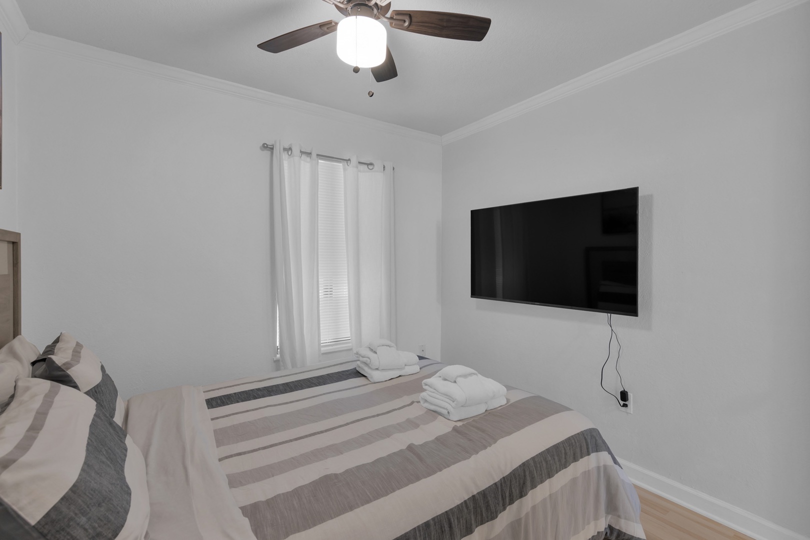 The private bedroom features a plush queen bed & Smart TV