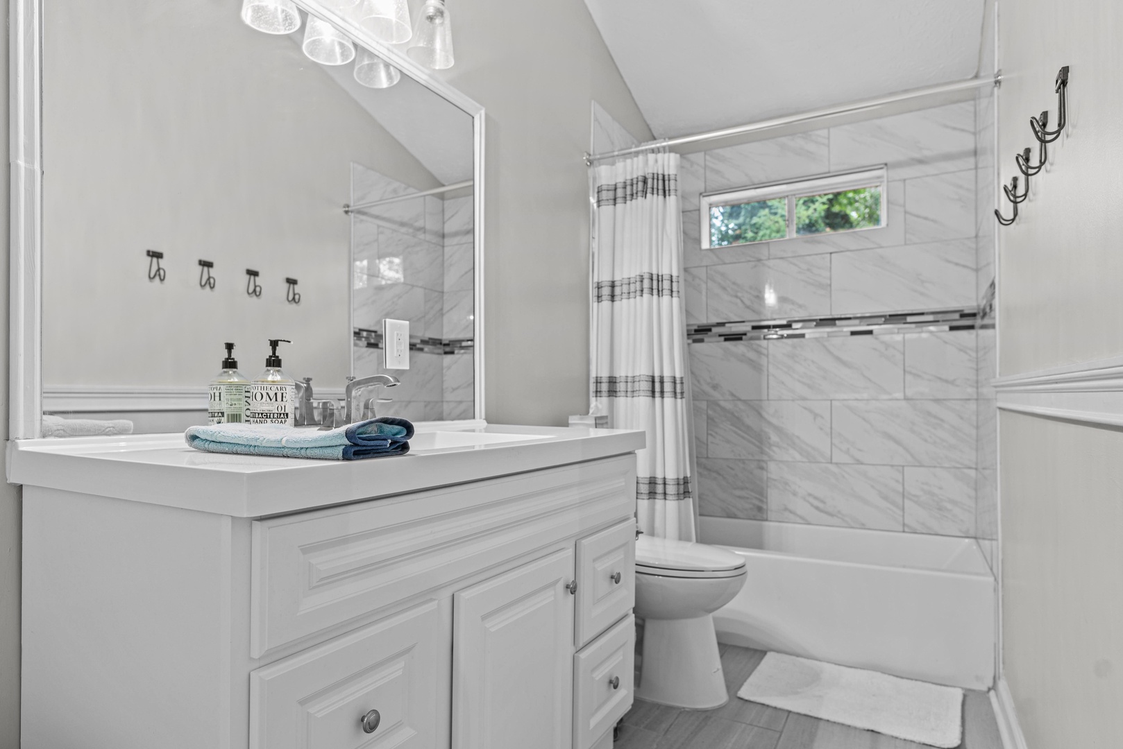 The full bathroom includes a single vanity & shower/tub combo