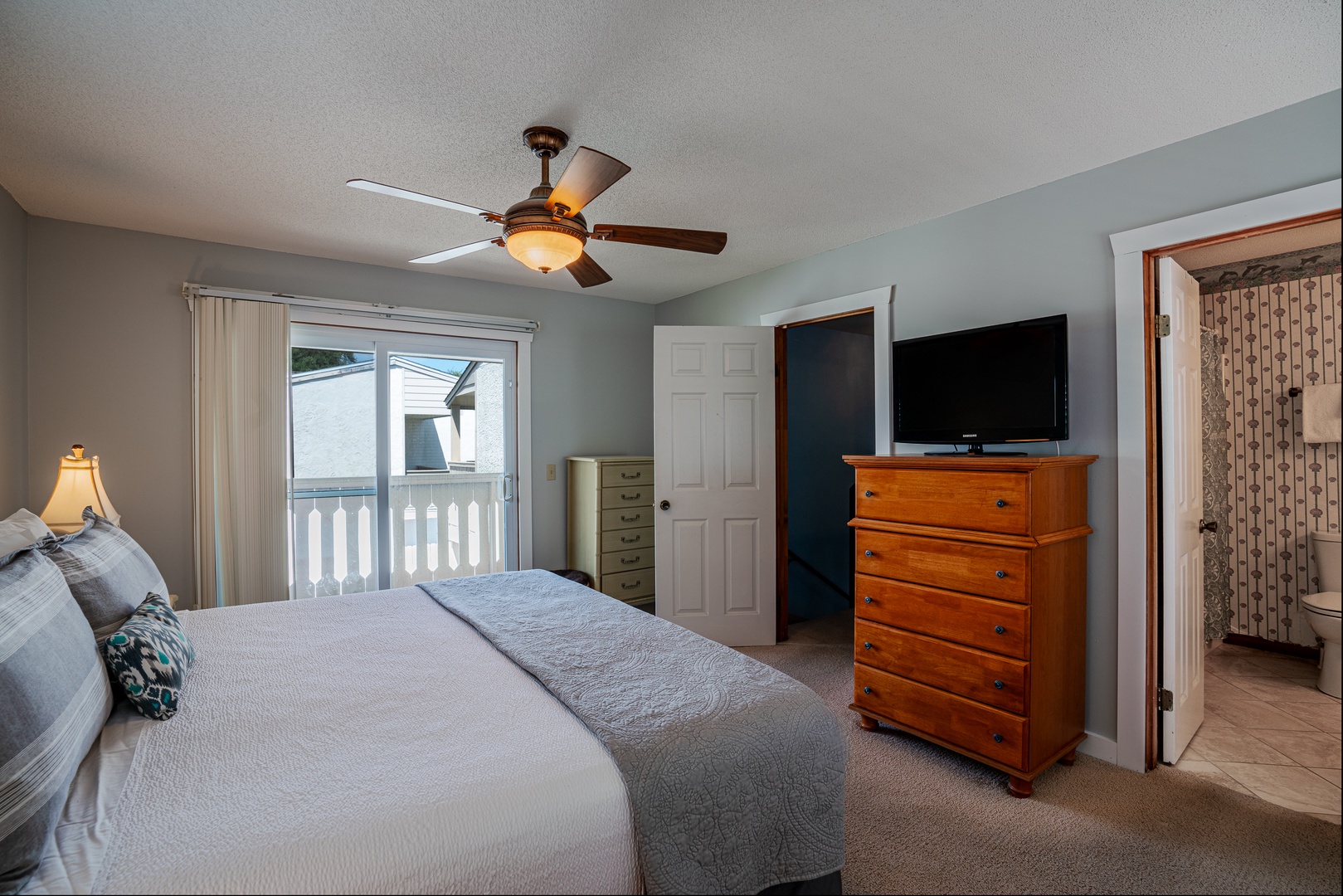 The king suite boasts a private ensuite, ceiling fan, TV, & balcony access