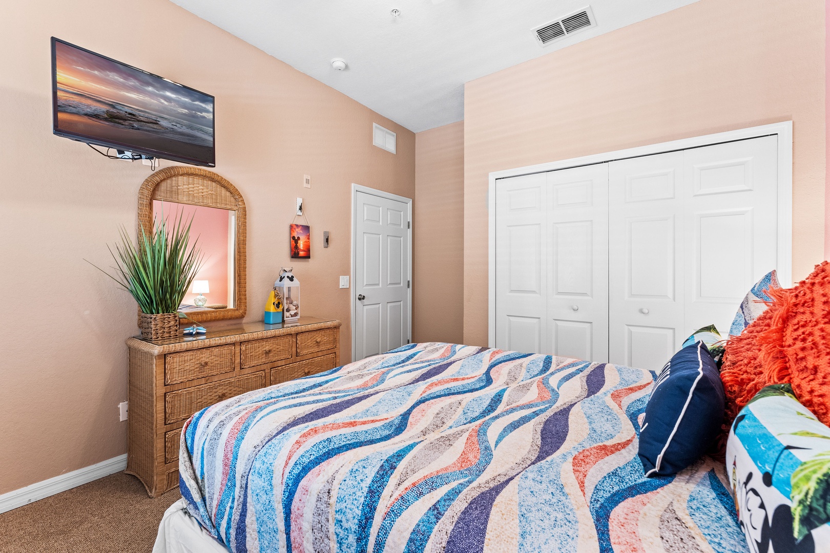 Bedroom retreat showcases a chic queen bed & smart TV