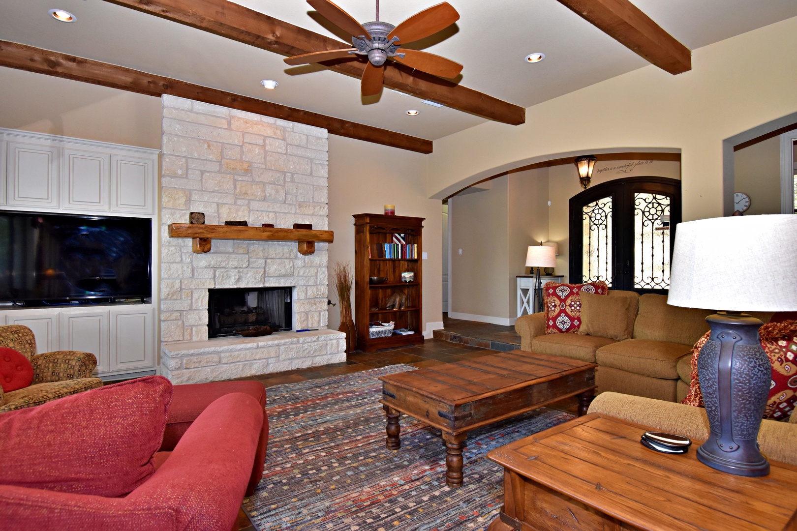 Open living space with lake view, TV, fireplace, and deck access