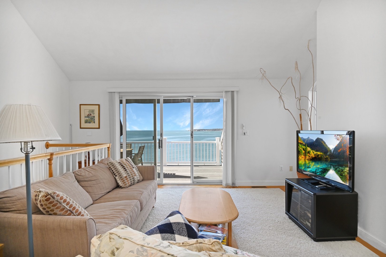 Upstairs living area with cozy seating, TV, work station, and balcony