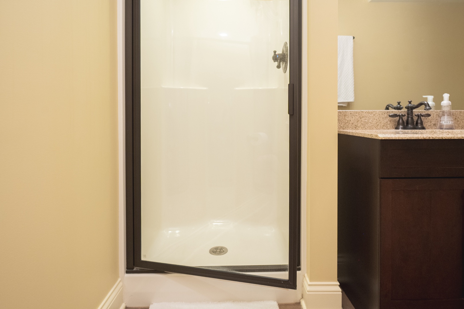 The lower-level full bathroom offers a single vanity & glass shower