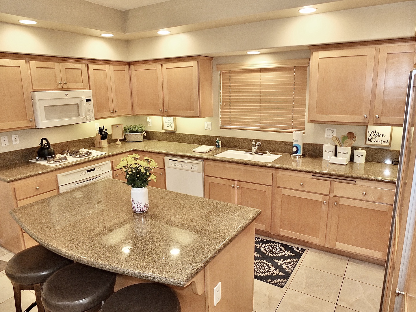 The open, airy kitchen has ample space & all the comforts of home