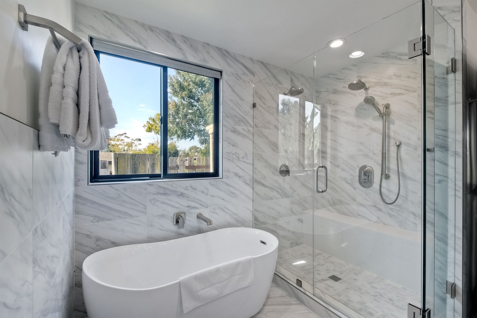 The master ensuite features a large vanity, glass shower, & luxe soaking tub