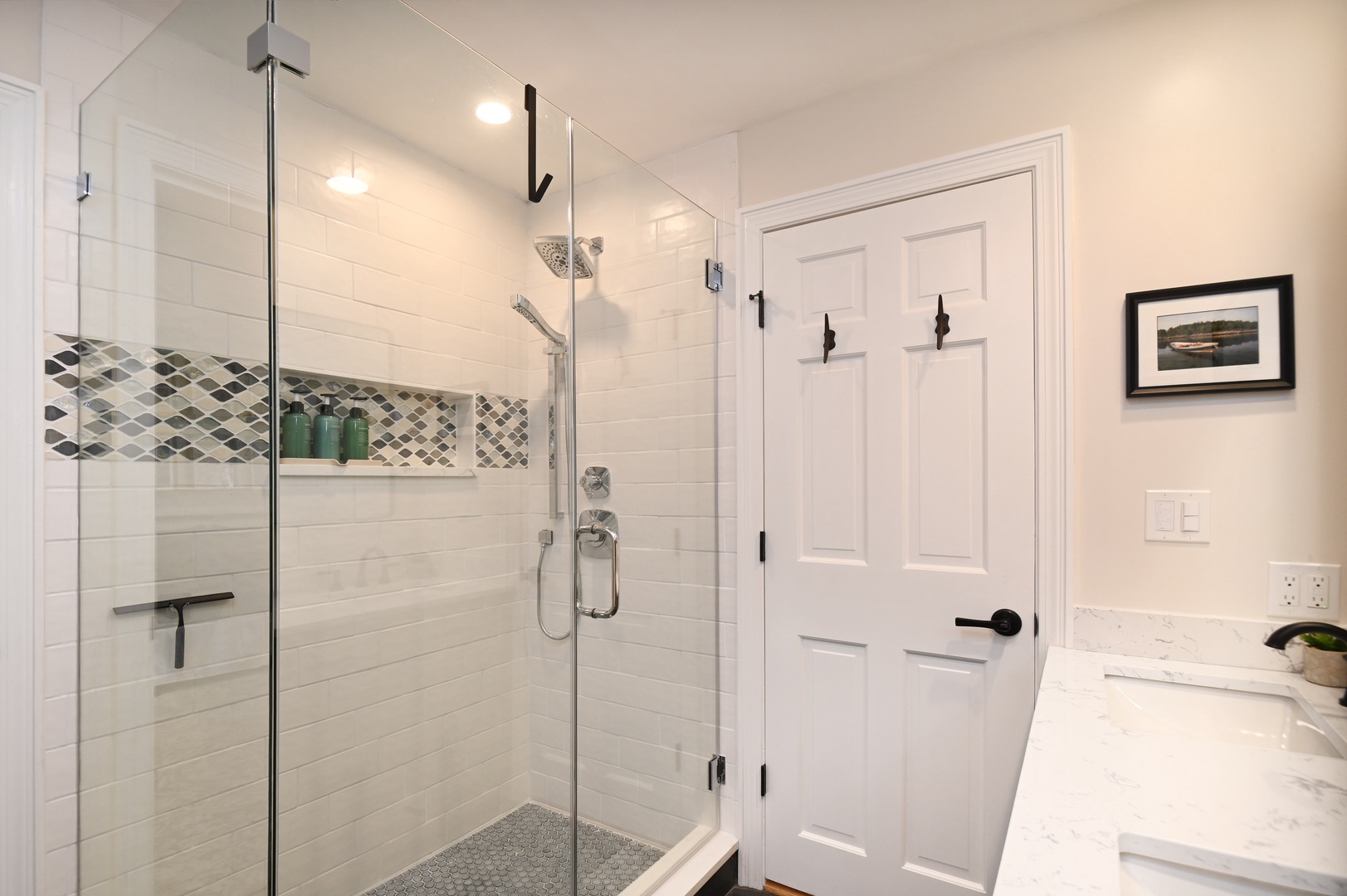 Playhouse’s stylish full bath showcases a double vanity & glass shower