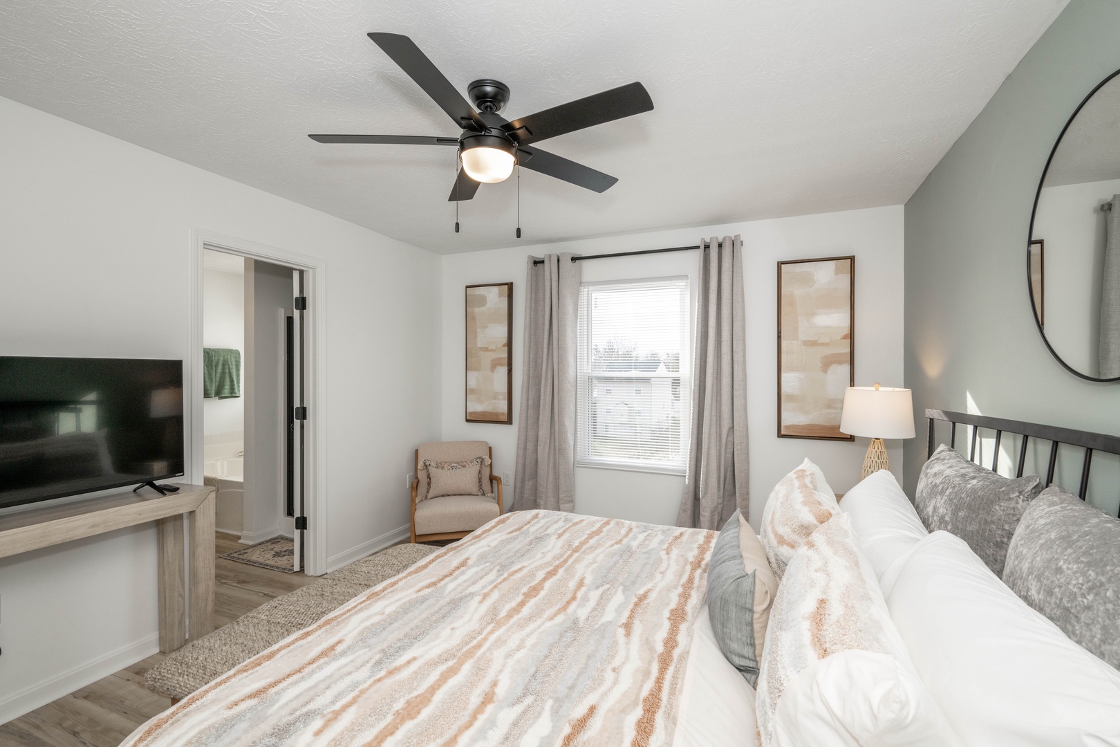 This calming bedroom retreat boasts a private ensuite, king bed, & Smart TV
