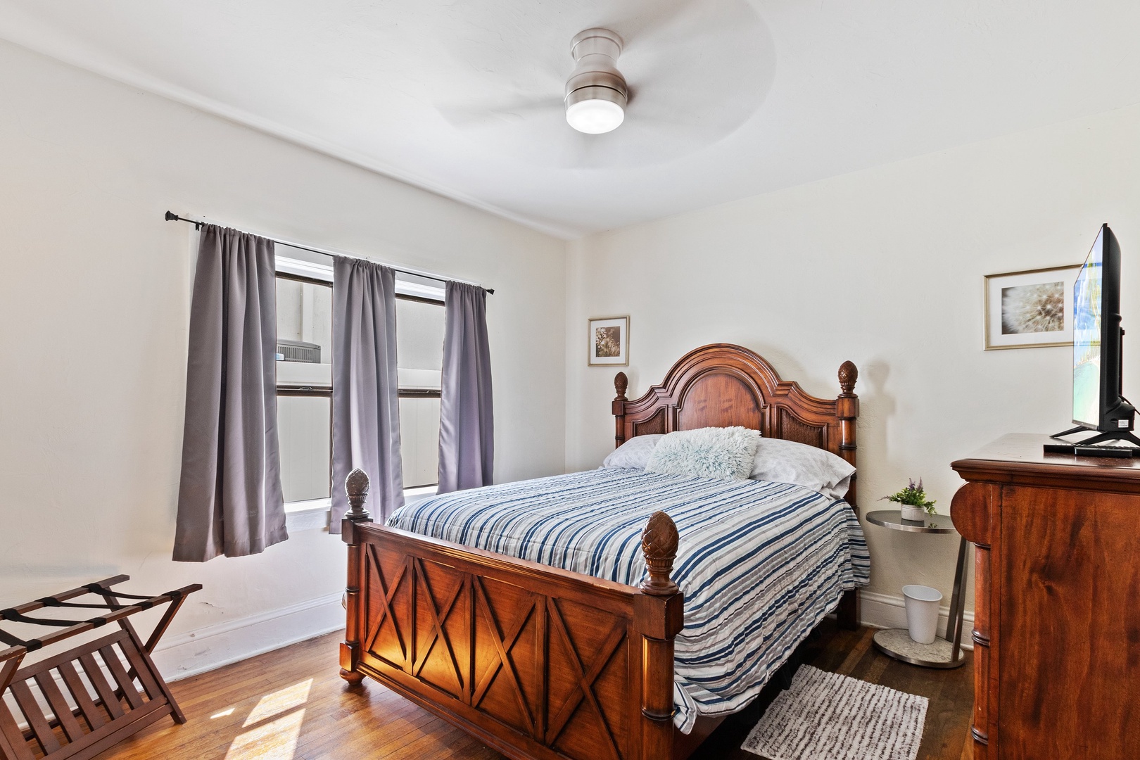 The first of three bedrooms offers a regal queen bed & TV