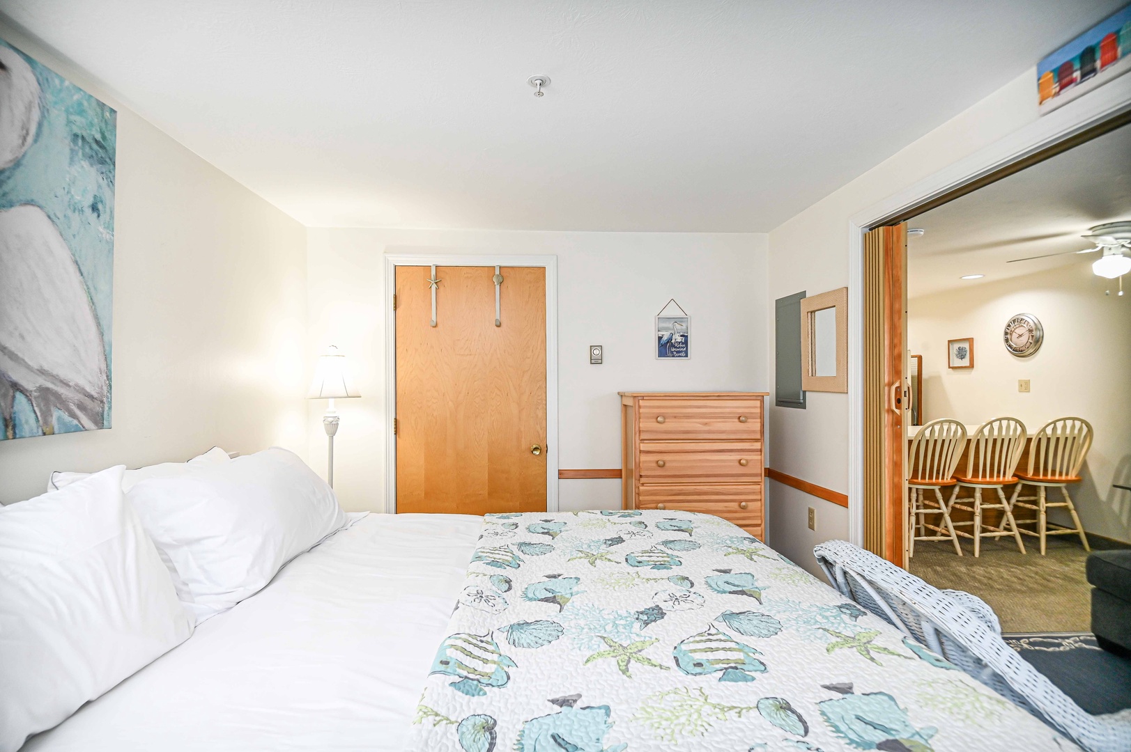 The spacious, coastal bedroom features a plush king-sized bed
