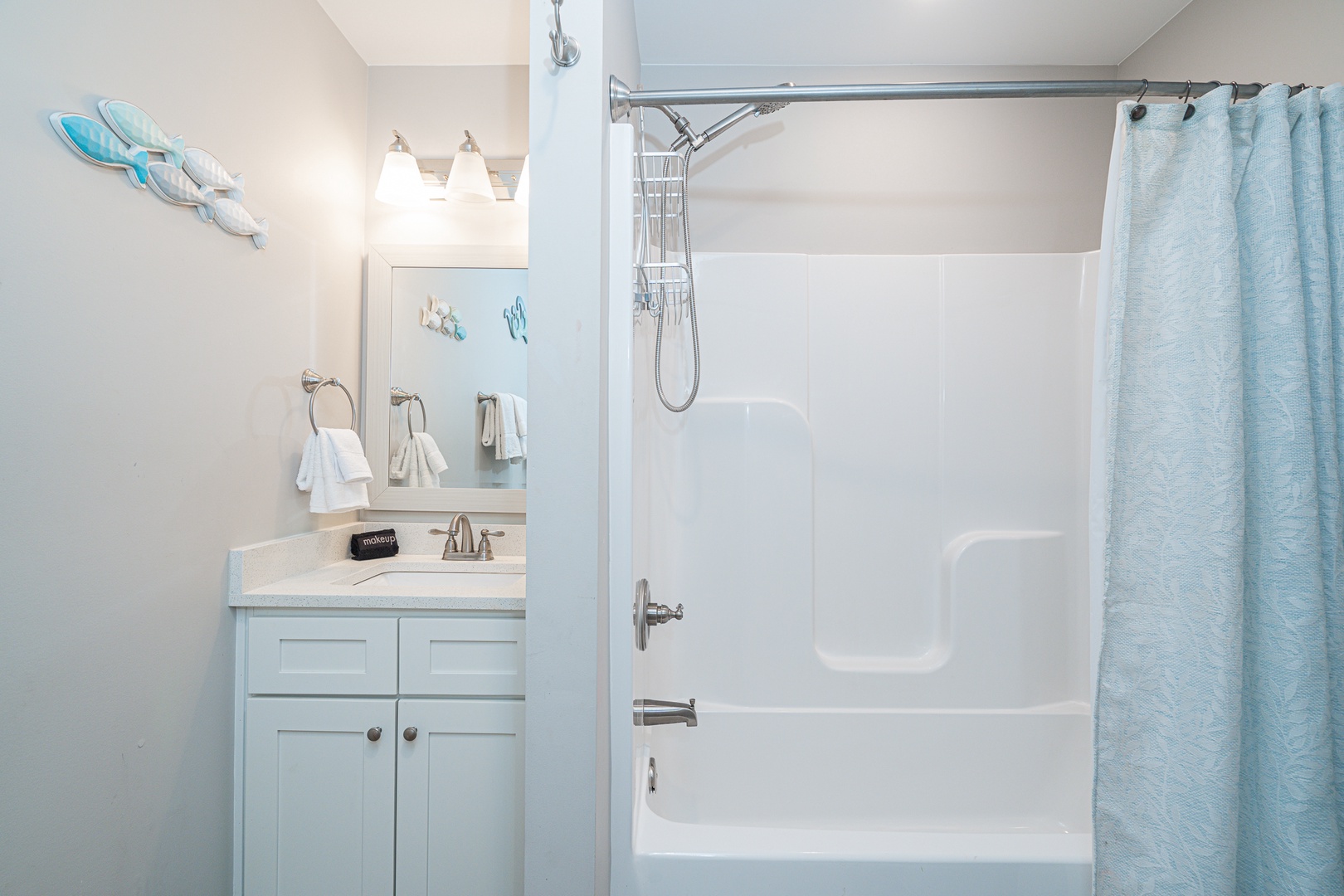 This shared full bathroom offers a single vanity & shower/tub combo