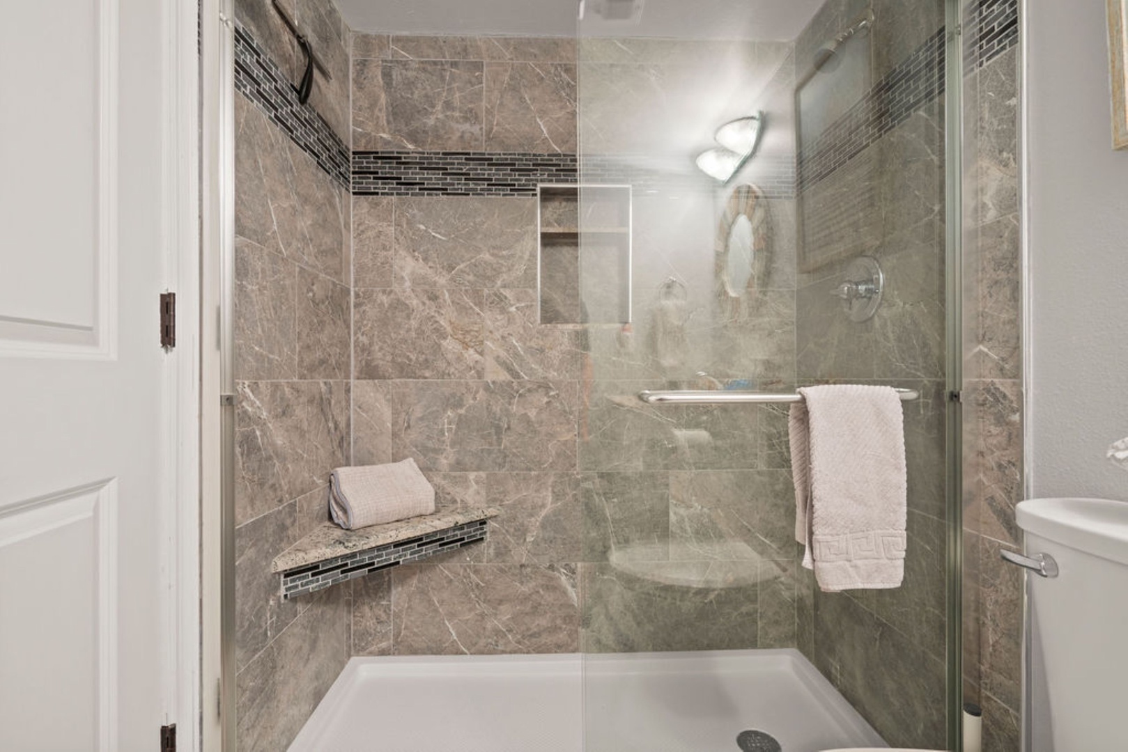 Modern shared bathroom featuring a walk-in shower with sleek glass doors
