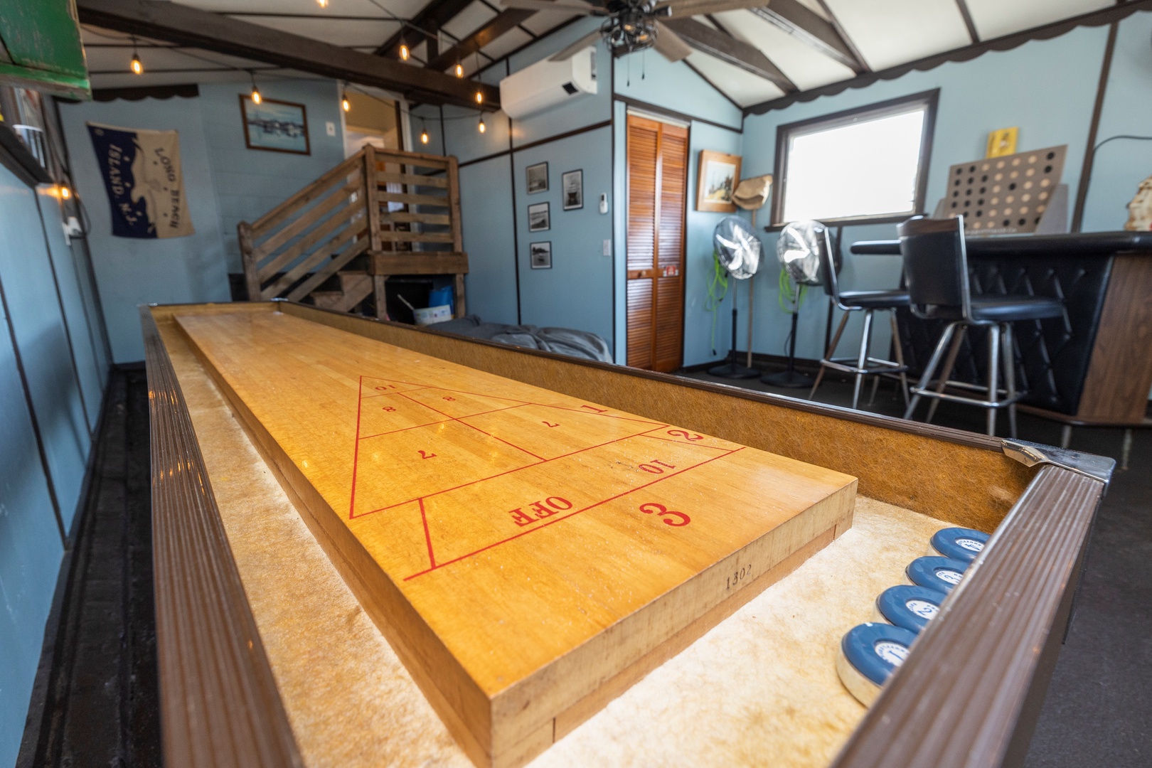 Game room with shuffleboard, TV, and bar
