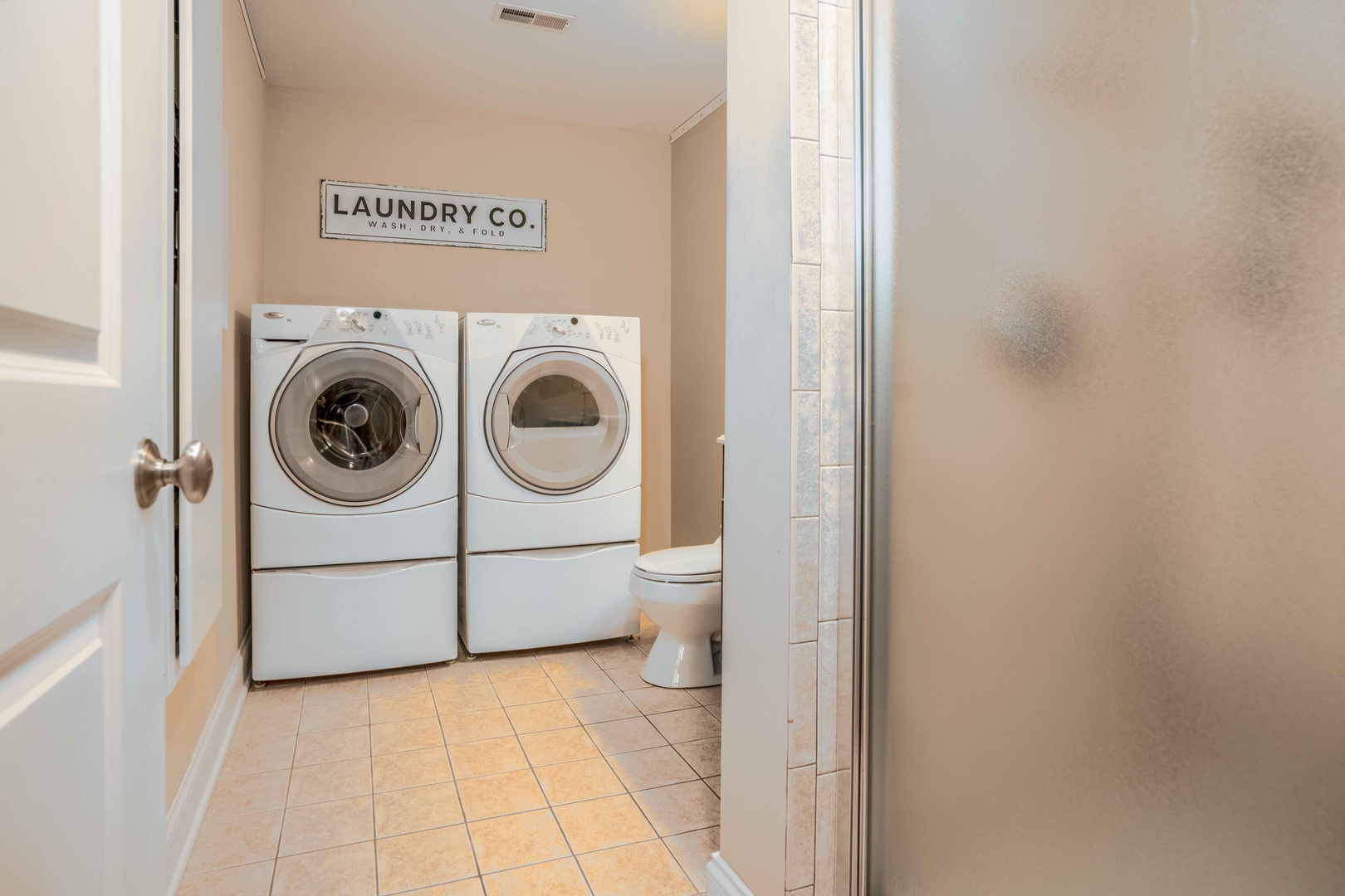 Shared bathroom with stand-up shower, and laundry area