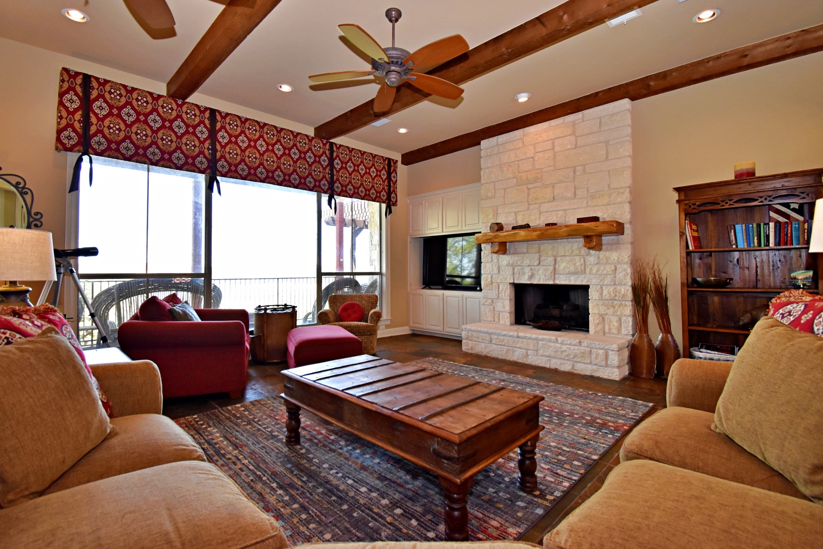 Open living space with lake view, TV, fireplace, and deck access