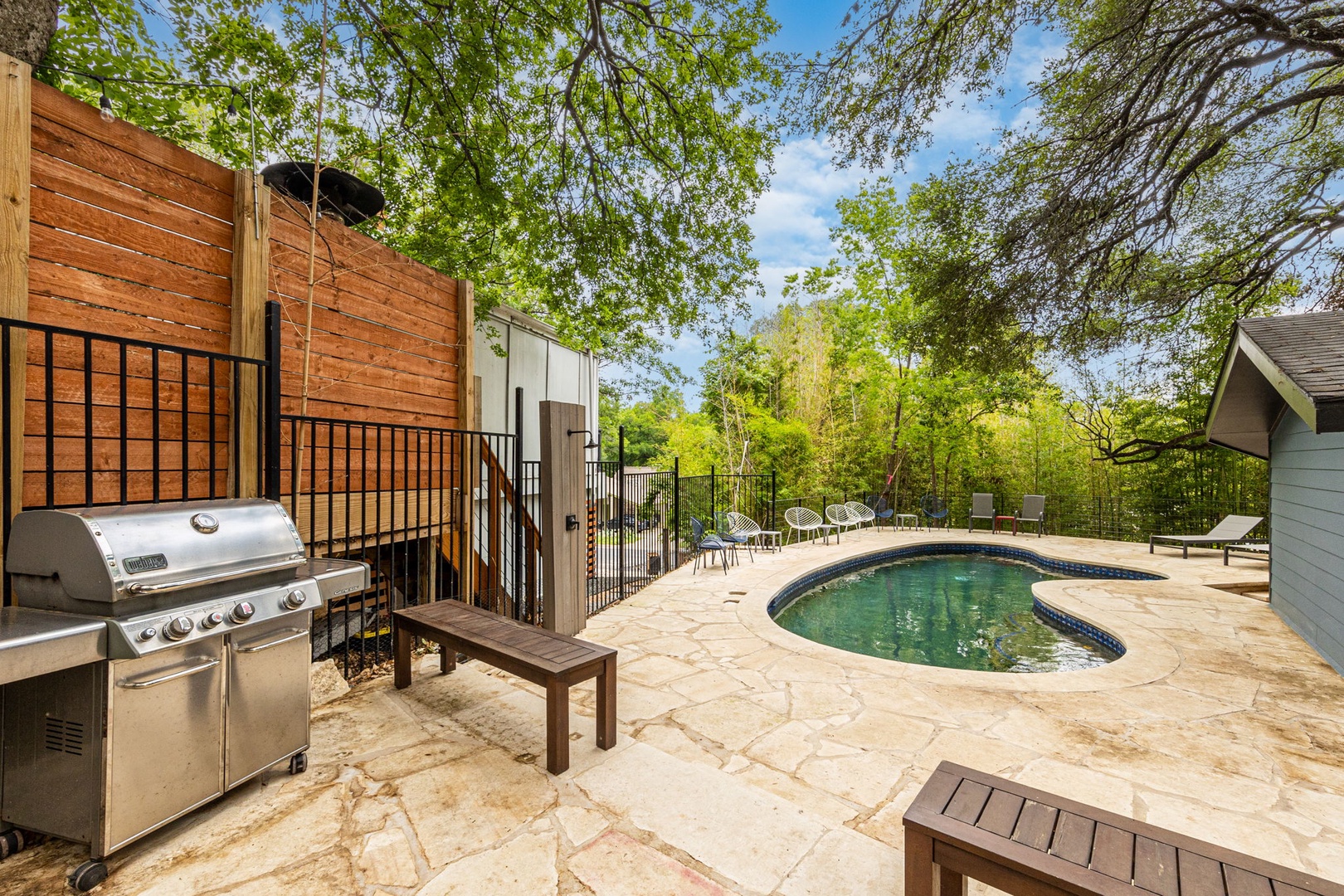 Outdoor area with pool, gas grill, outdoor shower area and ample seating