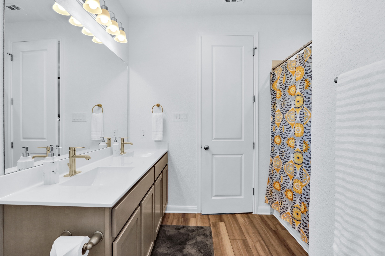 This chic ensuite features dual vanities, shower/tub combo