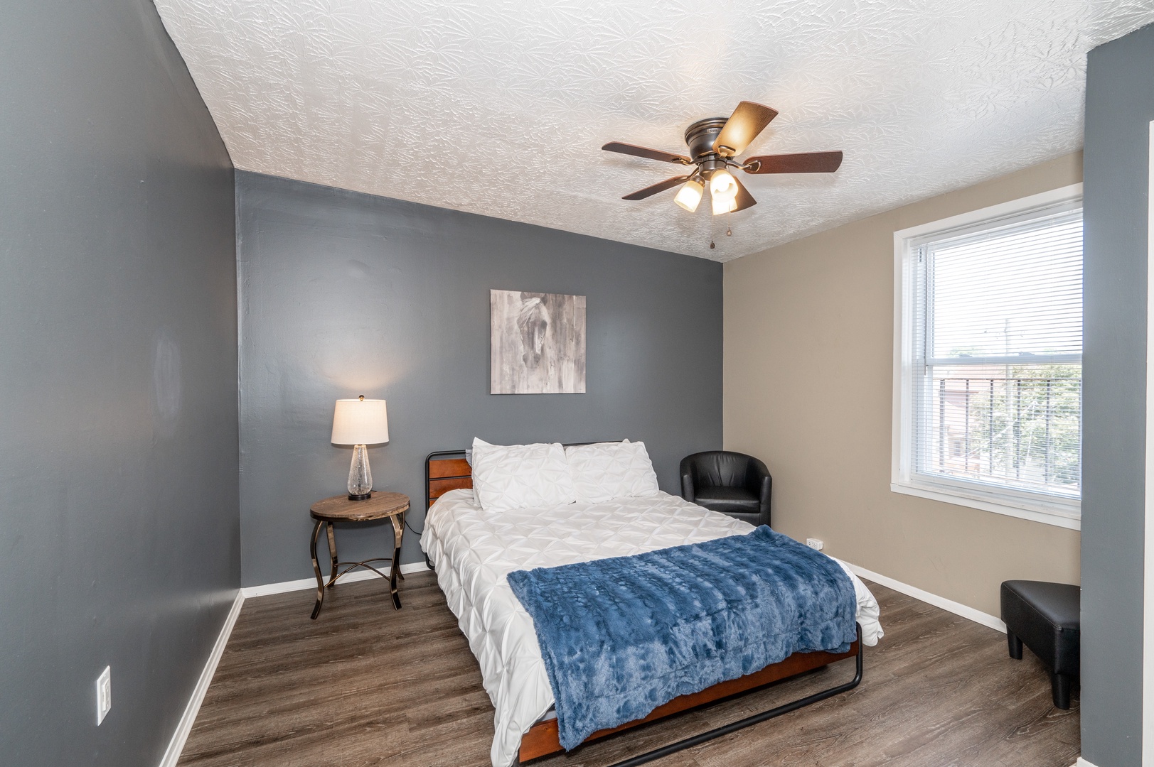 The spacious primary bedroom offers a queen bed & ceiling fan