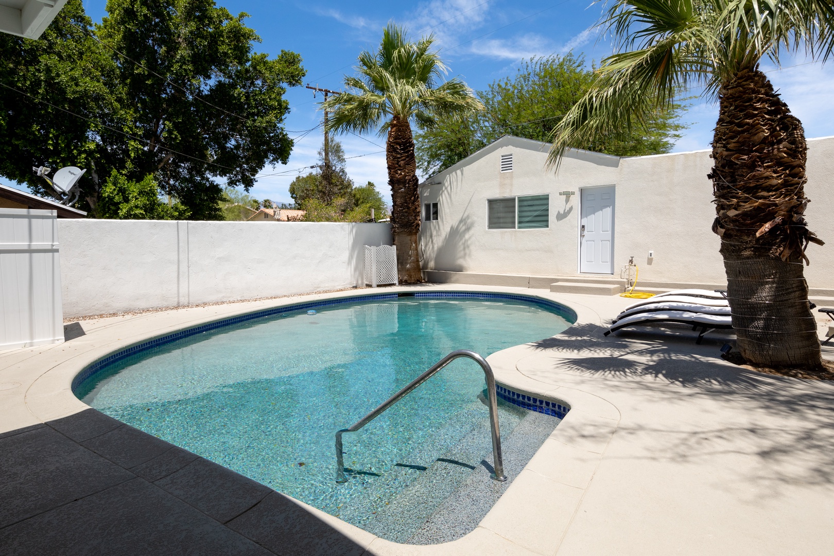 Large fenced in backyard with a pool