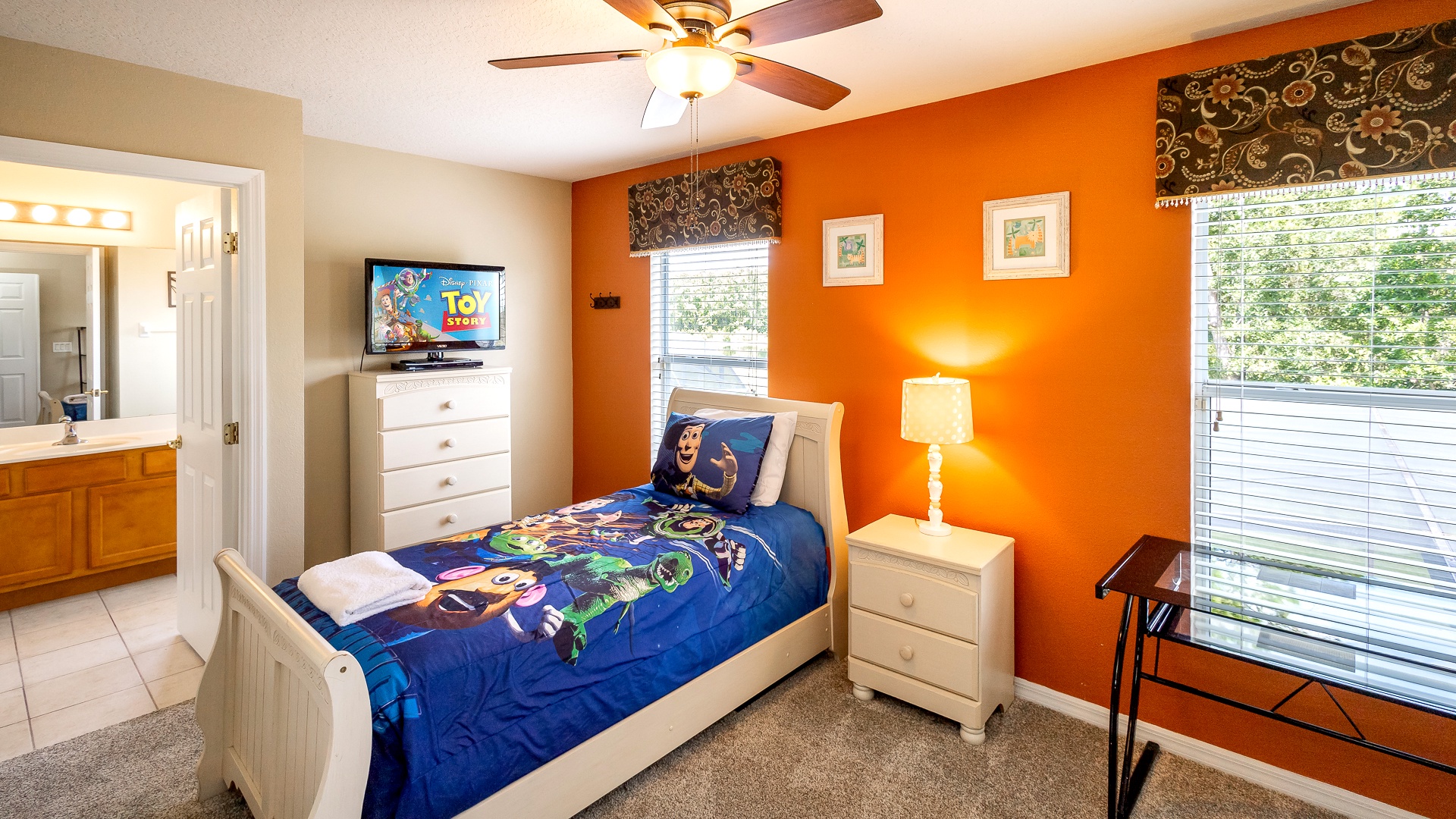 This twin bedroom includes a Jack and Jill bathroom, ceiling fan, & desk