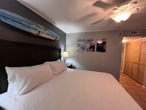 Bedroom 1 with King bed, lanai access, TV, and en-suite