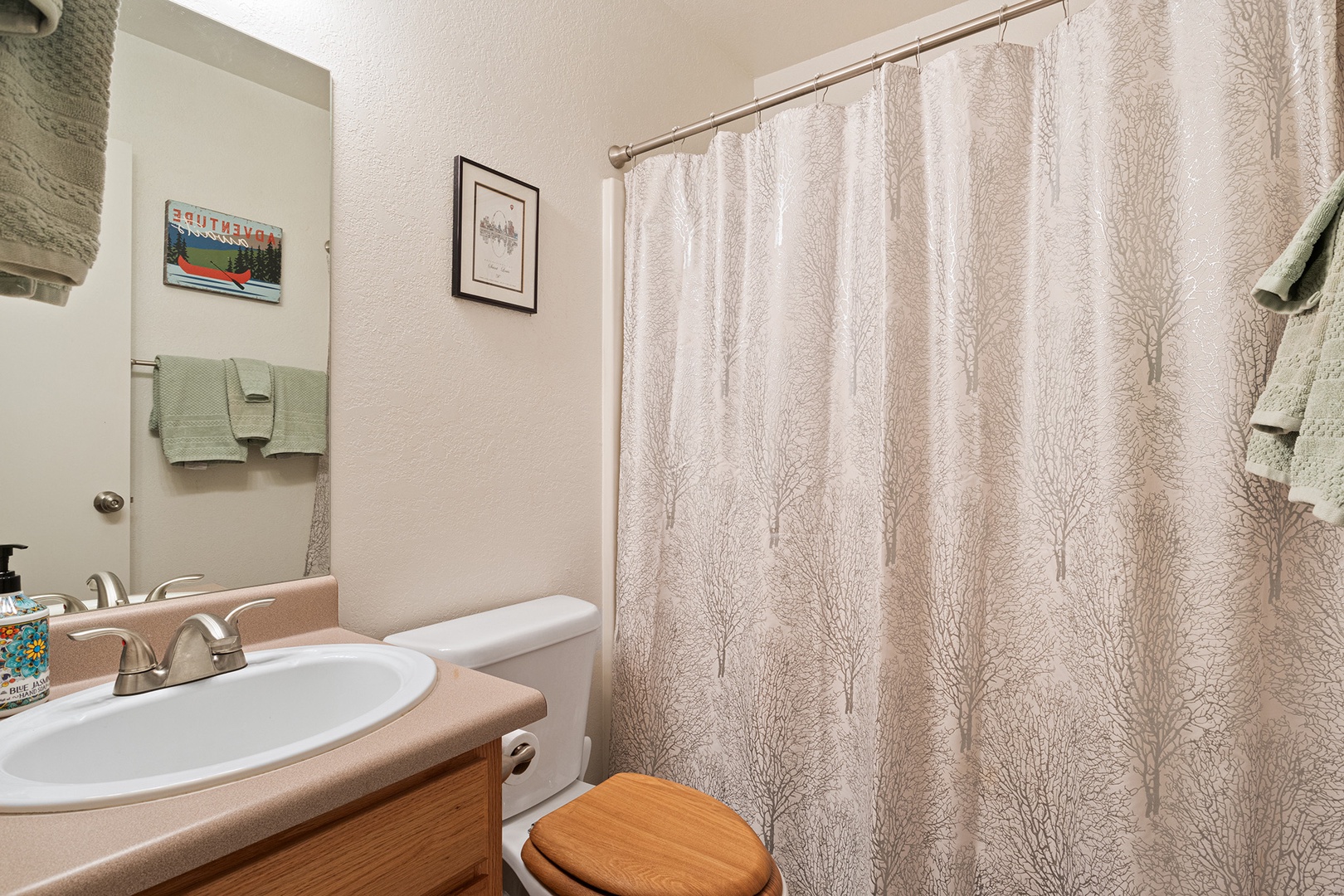 This ensuite bath features a single vanity with shower/tub combo