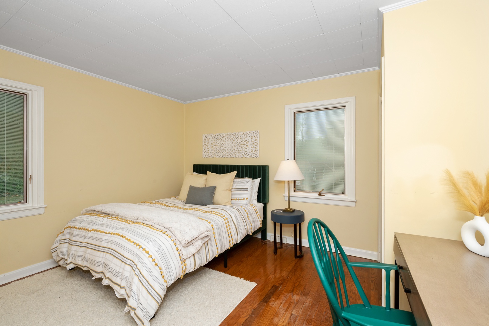 The spacious first-floor bedroom offers a queen bed & desk workspace