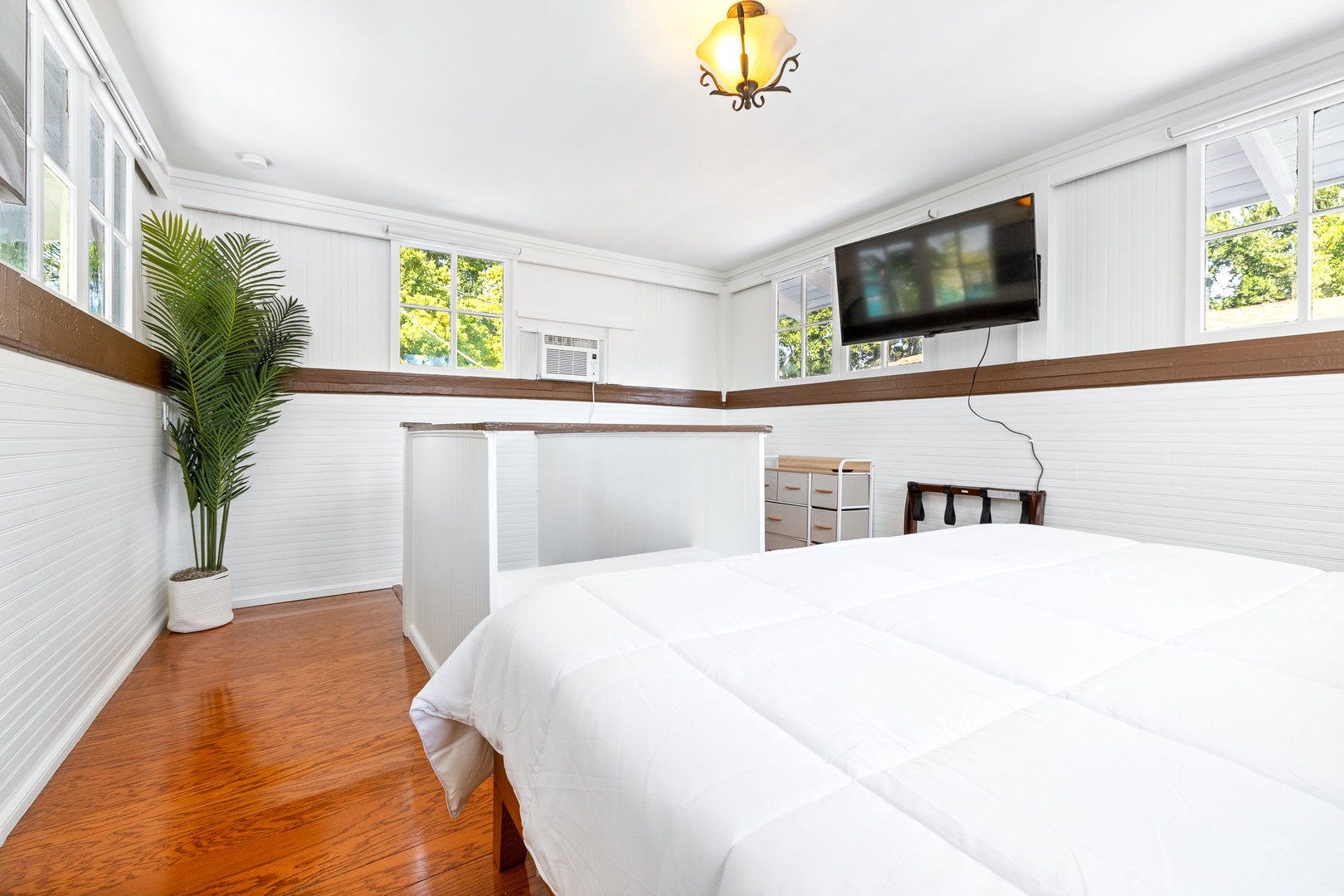 The sunny 2nd-level king bedroom offers a convenient desk & Smart TV