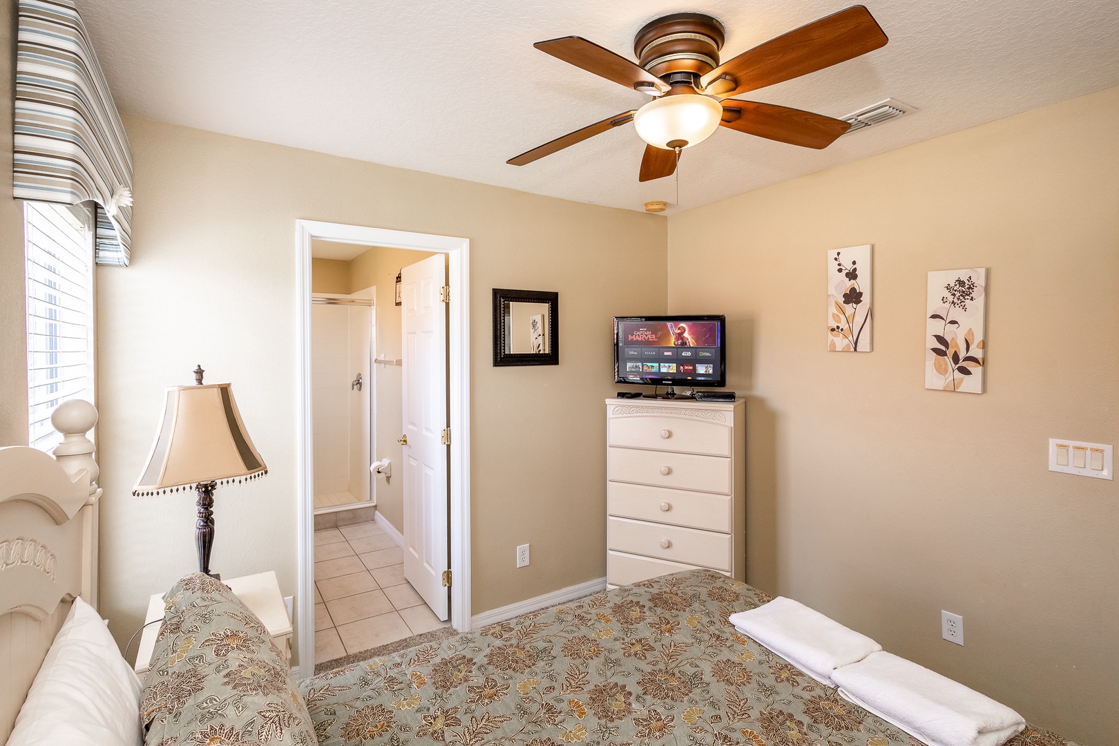 This queen suite offers a private en suite, TV, & ceiling fan