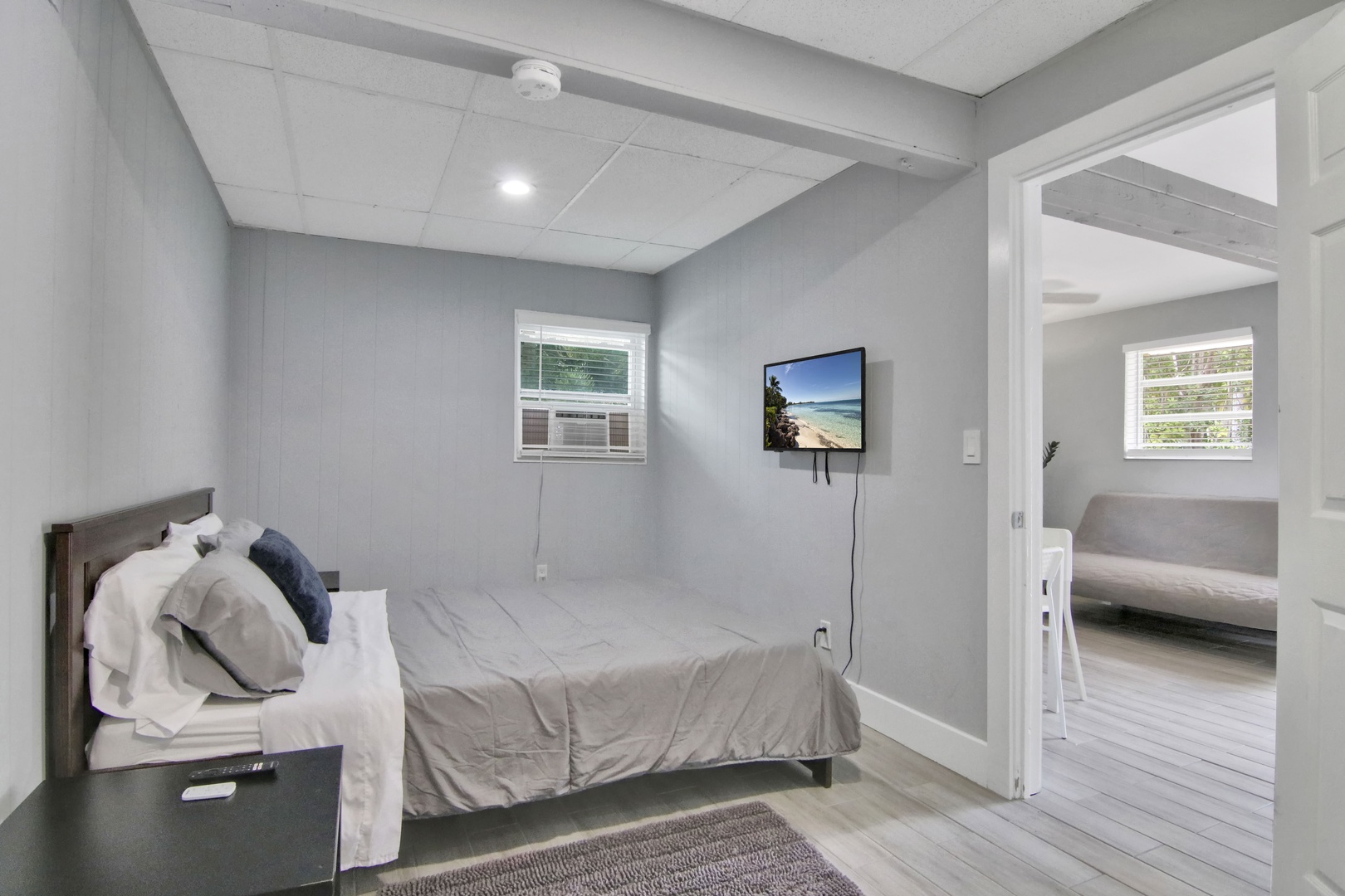 The serene bedroom offers a queen bed & Smart TV