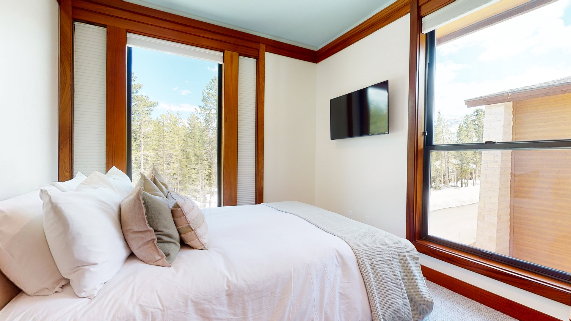 The 3rd floor queen bedroom boasts serene nature views and a Smart TV