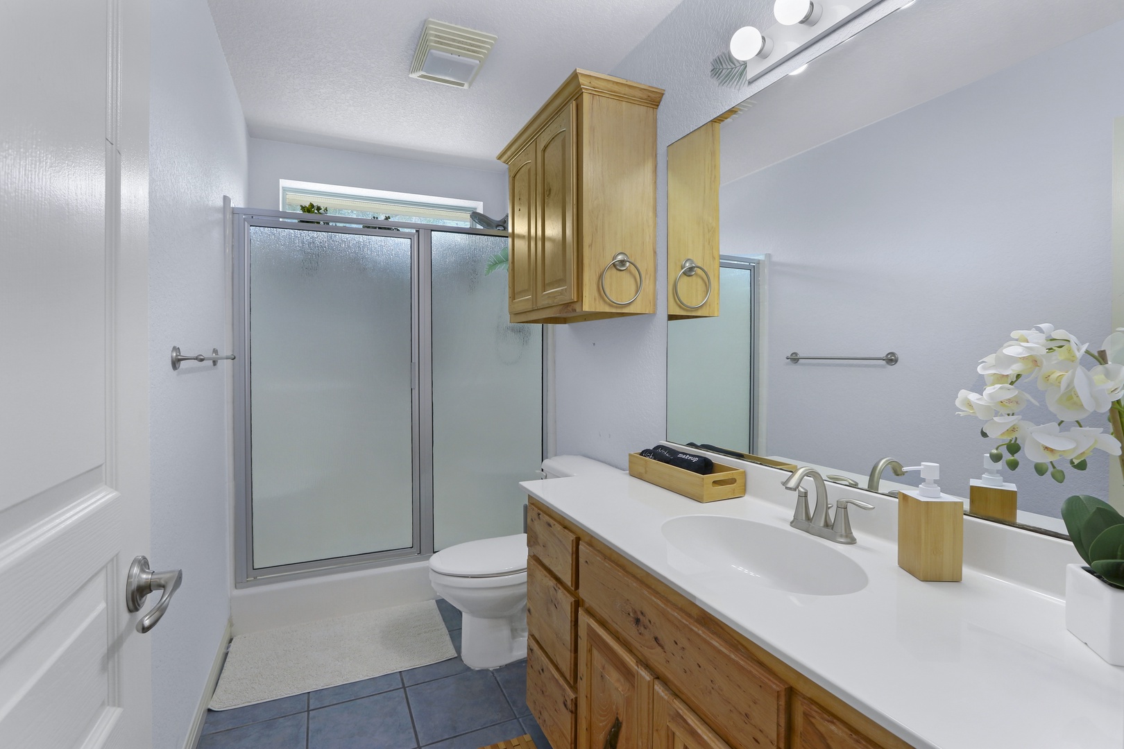 1 of 2 spacious full bathrooms, with an oversized vanity & glass shower