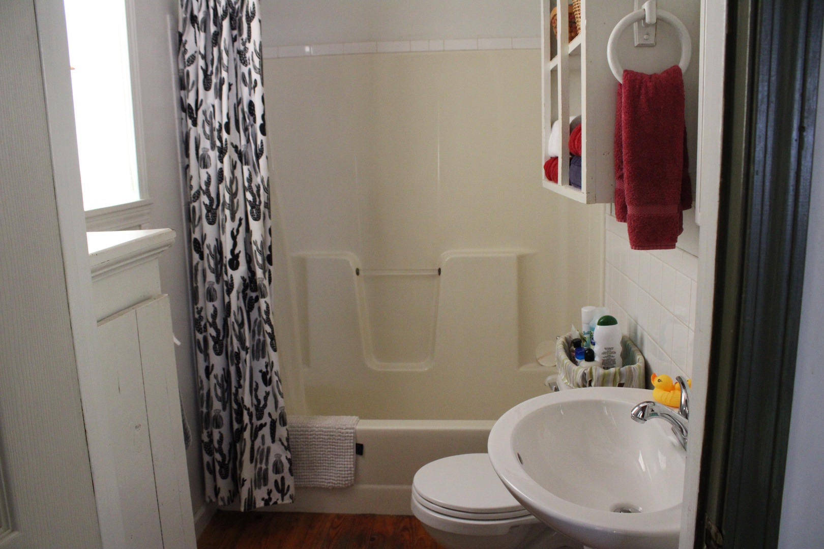 This home’s full bathroom includes a pedestal sink & shower/tub combo
