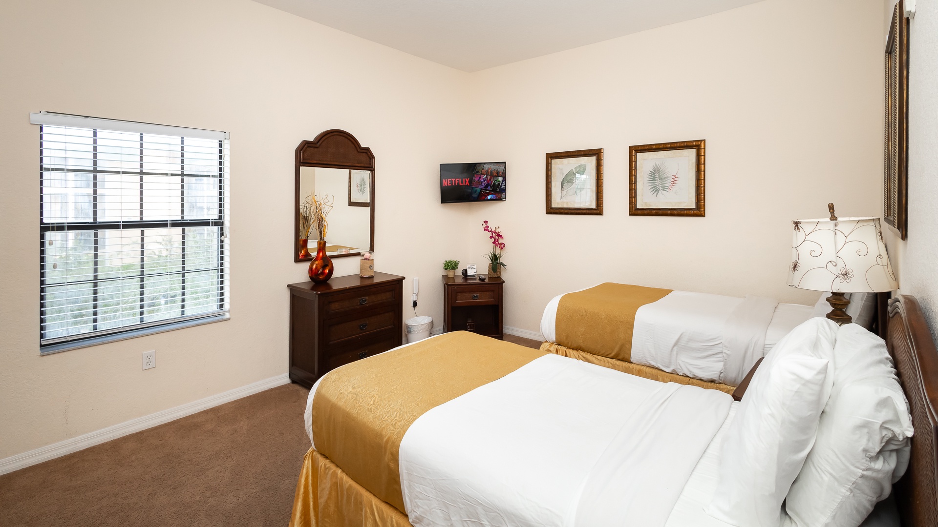A pair of cozy twin beds, private en suite, & TV await in the second bedroom