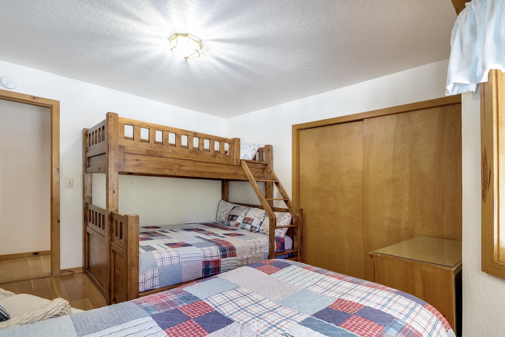 Relax in this cozy bedroom featuring a queen bunk bed and a comfortable queen bed.