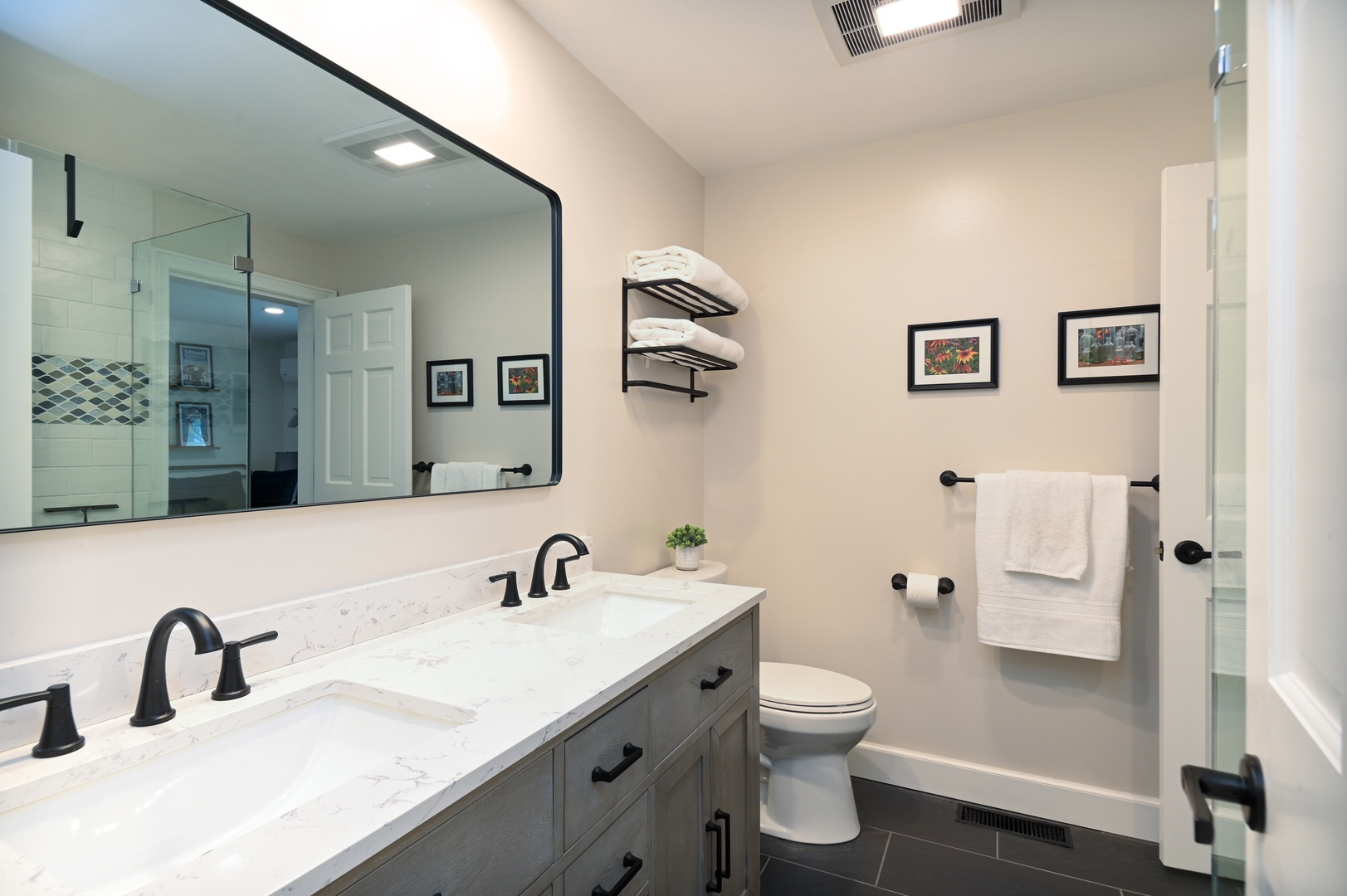 Playhouse’s stylish full bath showcases a double vanity & glass shower