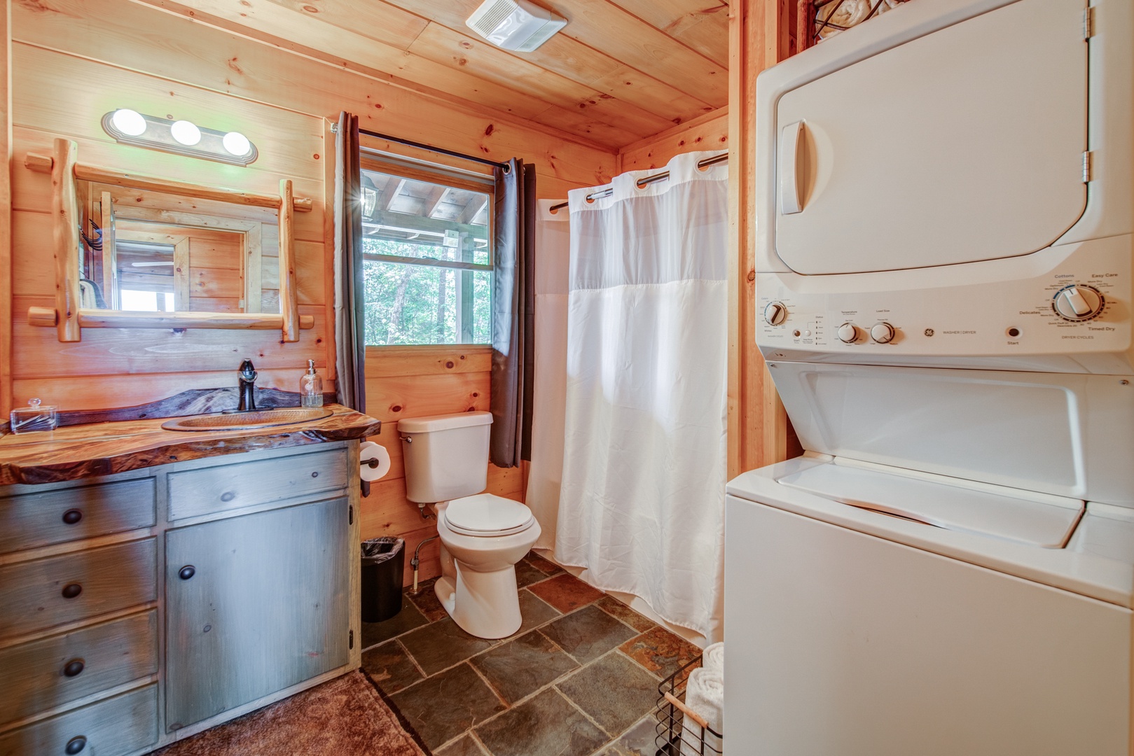 Private laundry, a single vanity, & shower await in the main-level full bath