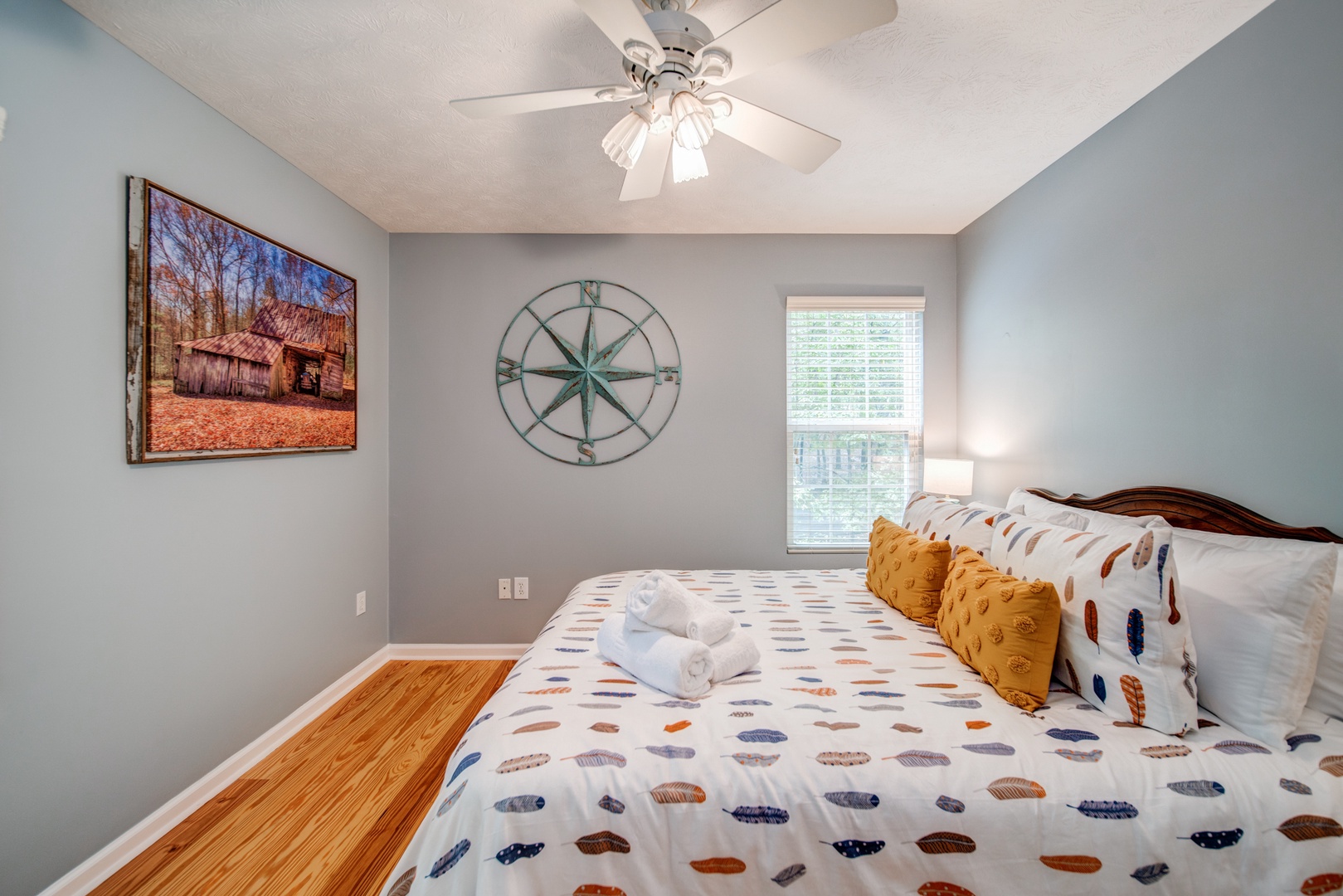 The second of two queen bedrooms, with a dresser & ceiling fan