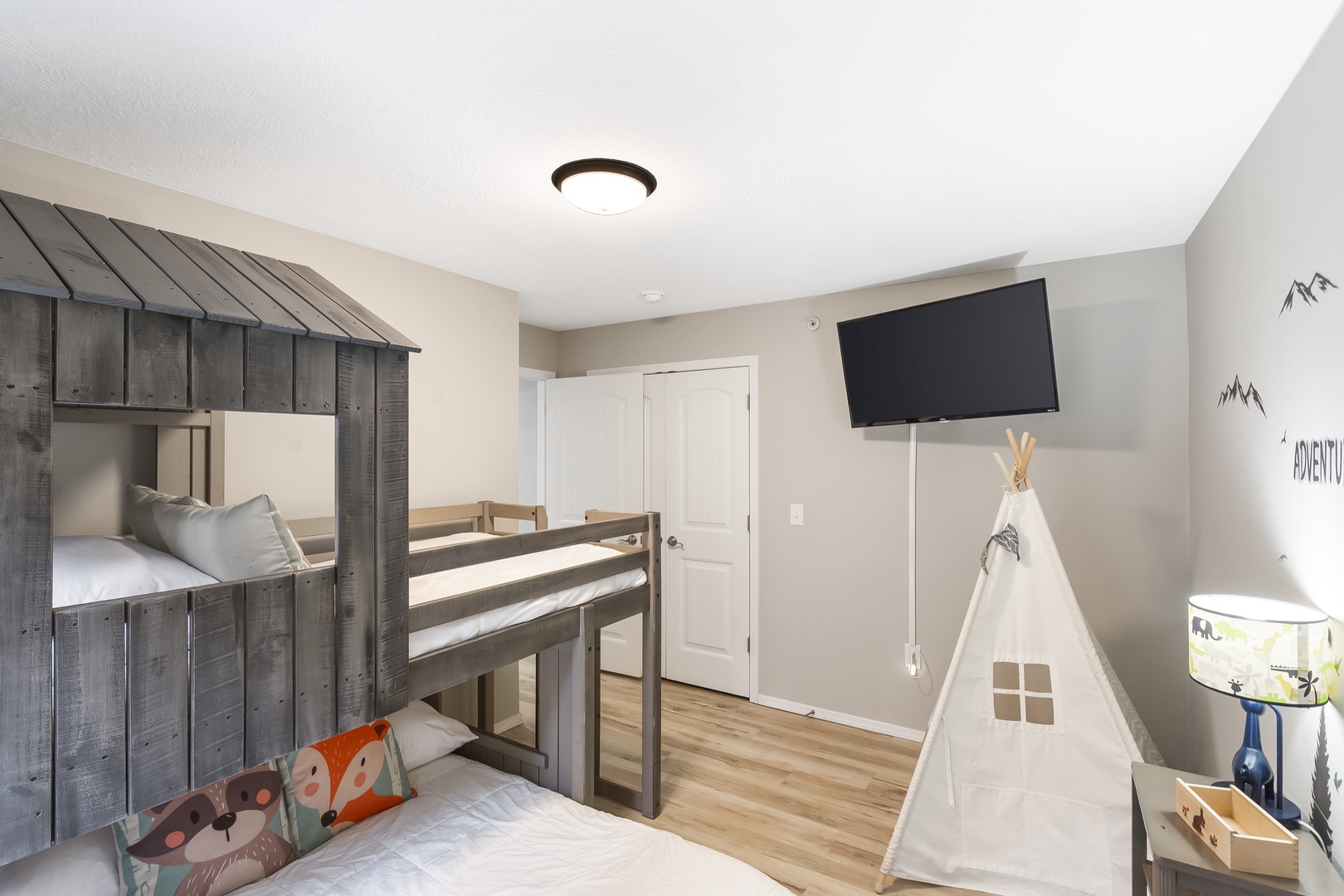 Kids will adore this camp-style bedroom with twin-over-full bunk beds & Smart TV