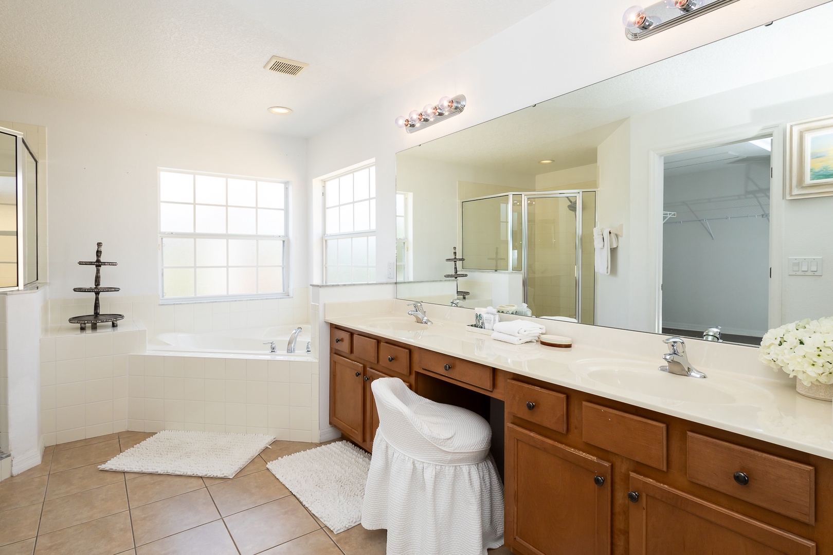 The master ensuite features a double vanity, shower, tub, & walk-in closet