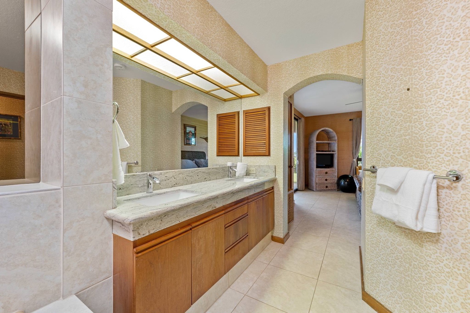 En suite bathroom with soaking tub, standing shower, and dual sinks