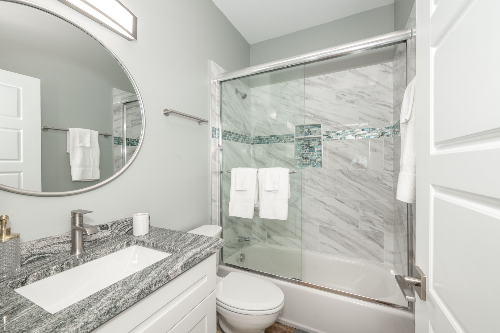 The polished full bathroom includes a single vanity & shower/tub combo