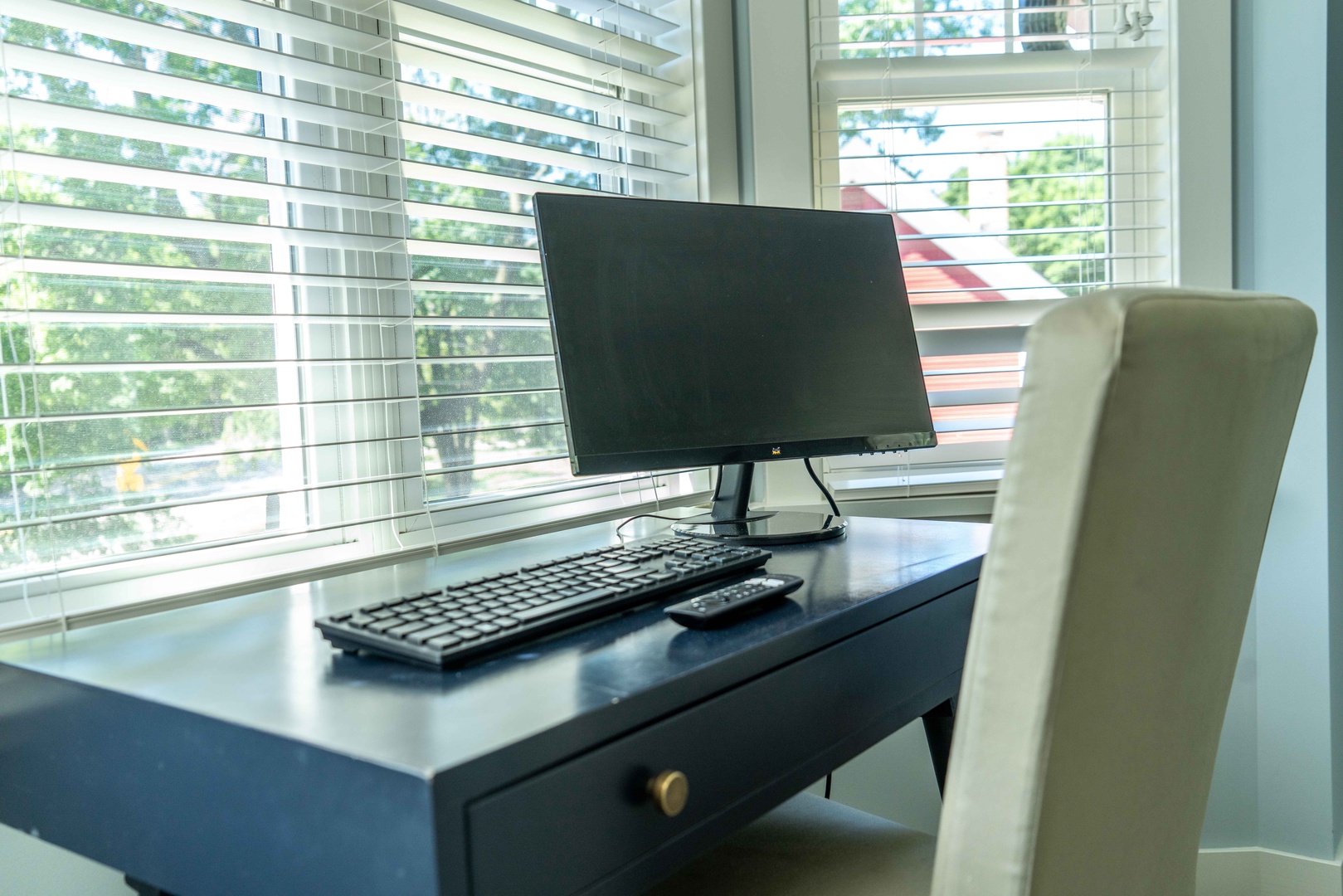 The second bedroom sanctuary features a plush queen bed, smart TV, and laptop workspace