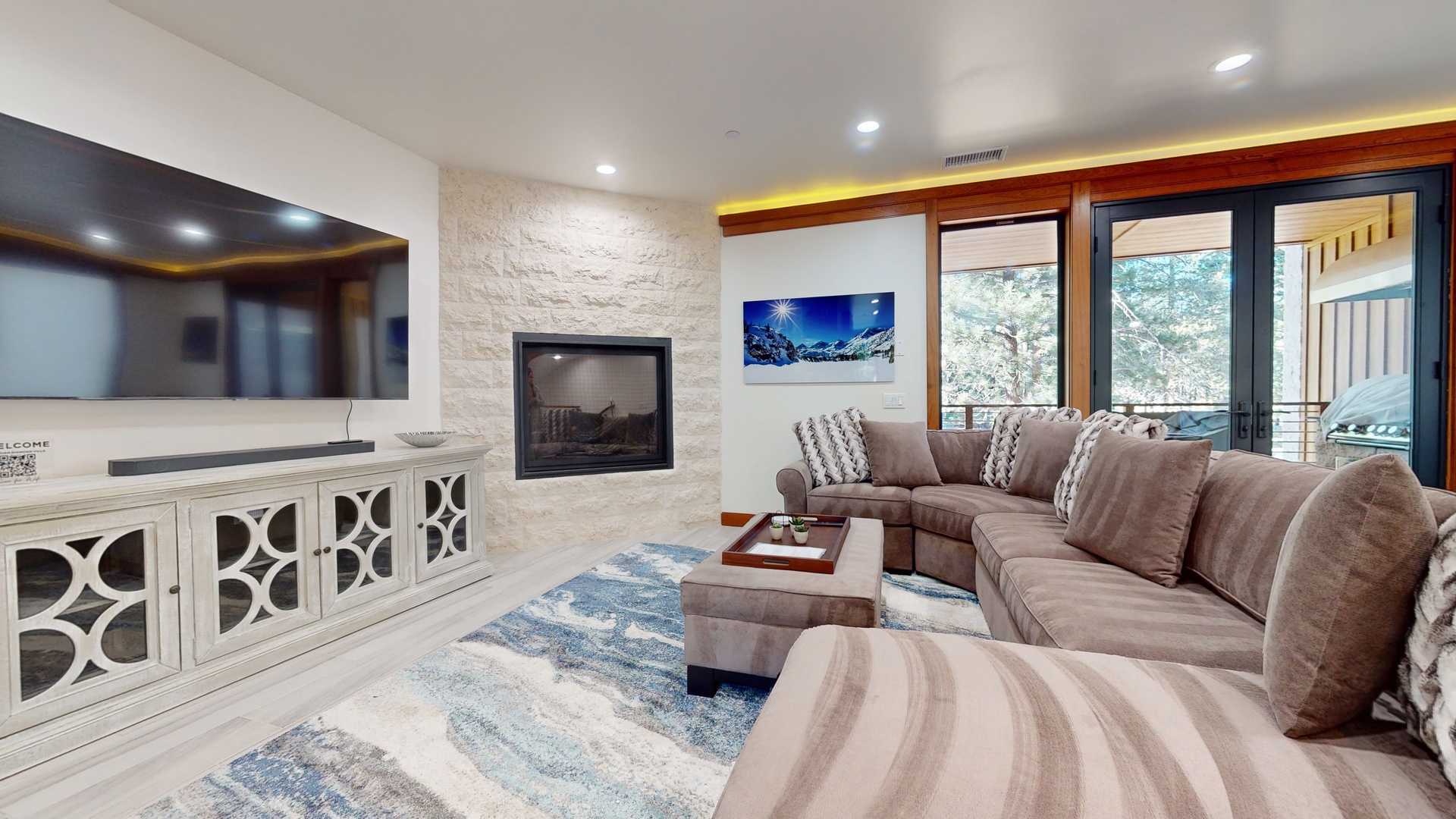 Open living space with balcony access, Smart TV, gas fireplace, and ample seating