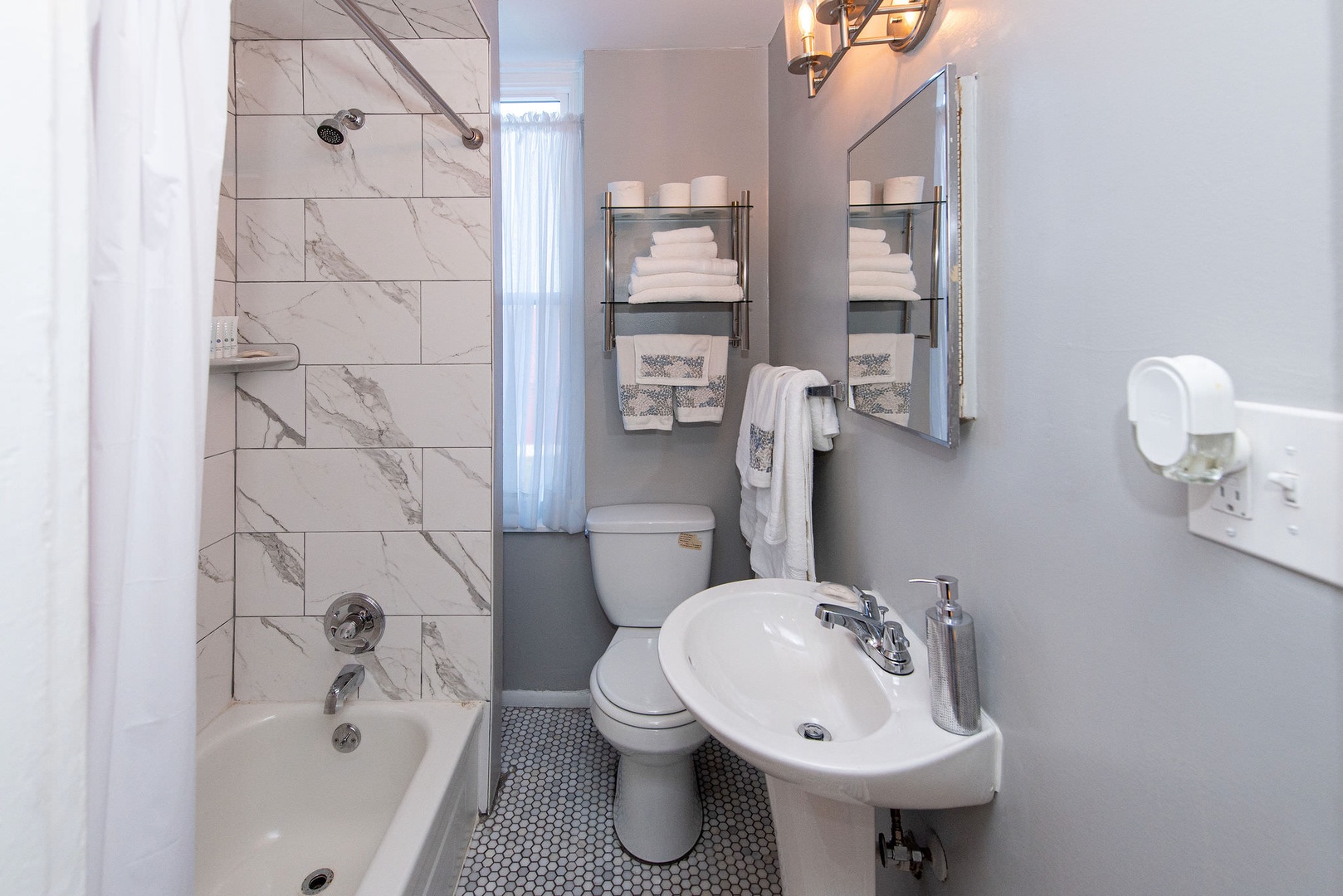 The full bathroom includes a pedestal sink & shower/tub combo