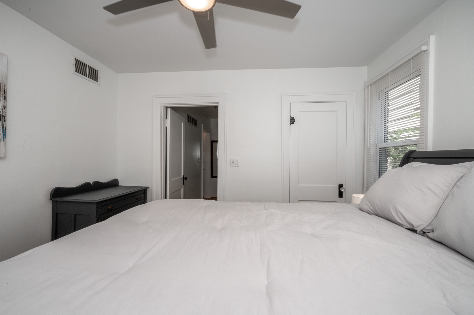 Unit 1 – The tranquil queen bedroom includes a ceiling fan & standing mirror